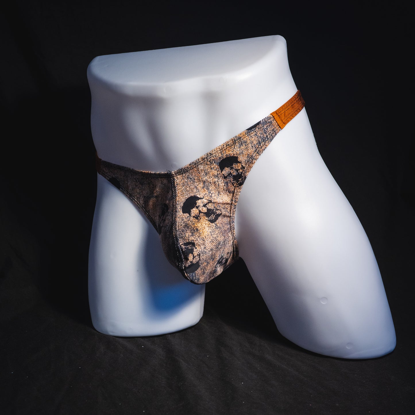 Men's black skulls on brown thong underwear, Classic cut, full angled front view.