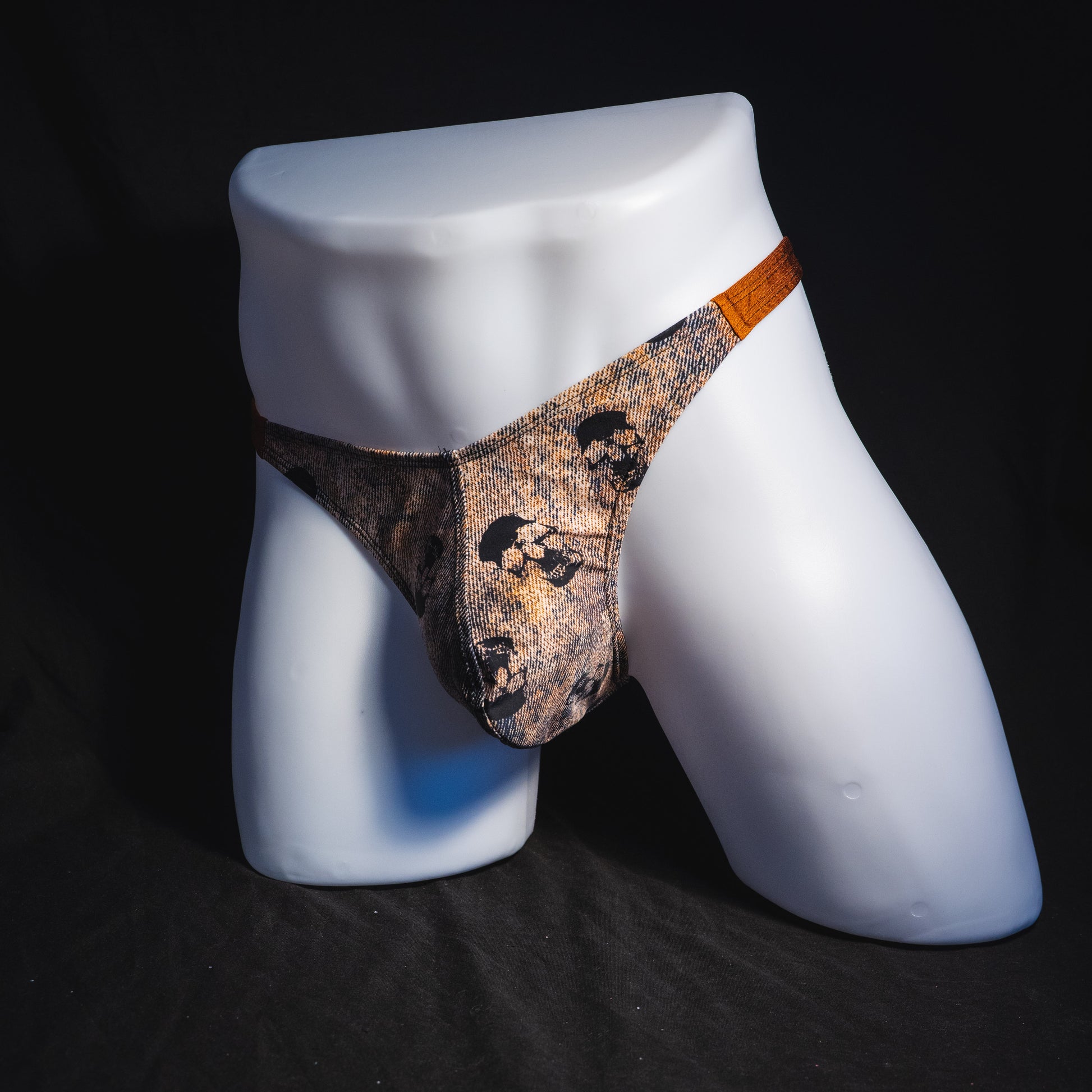 Men's black skulls on brown thong underwear, Classic cut, full angled front view.