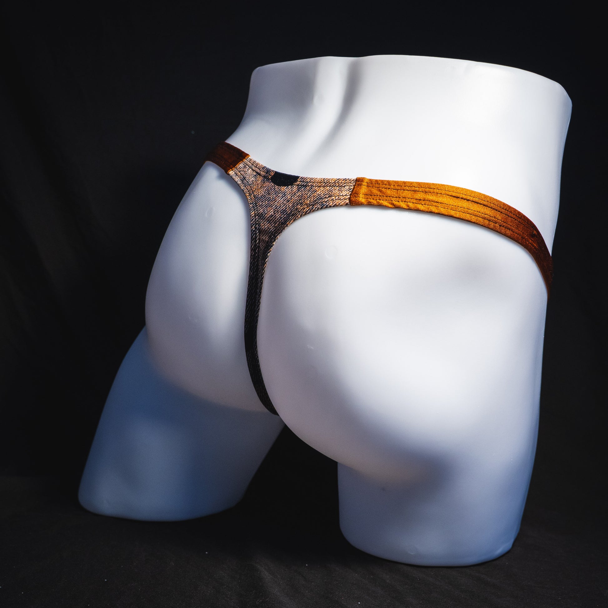 Men's black skulls on brown thong underwear, Classic cut, full angled rear view.