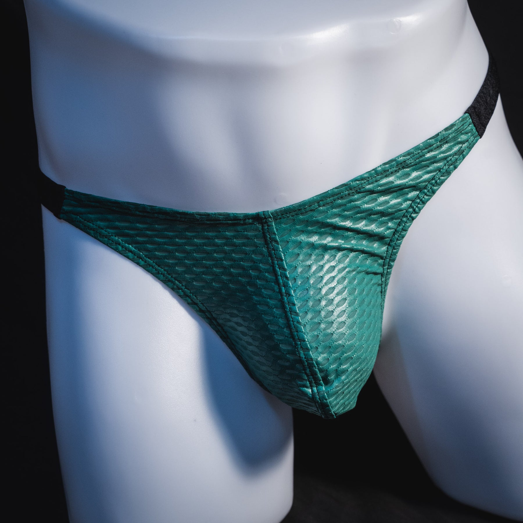 Men's green and black mesh thong underwear, classic cut, front view.