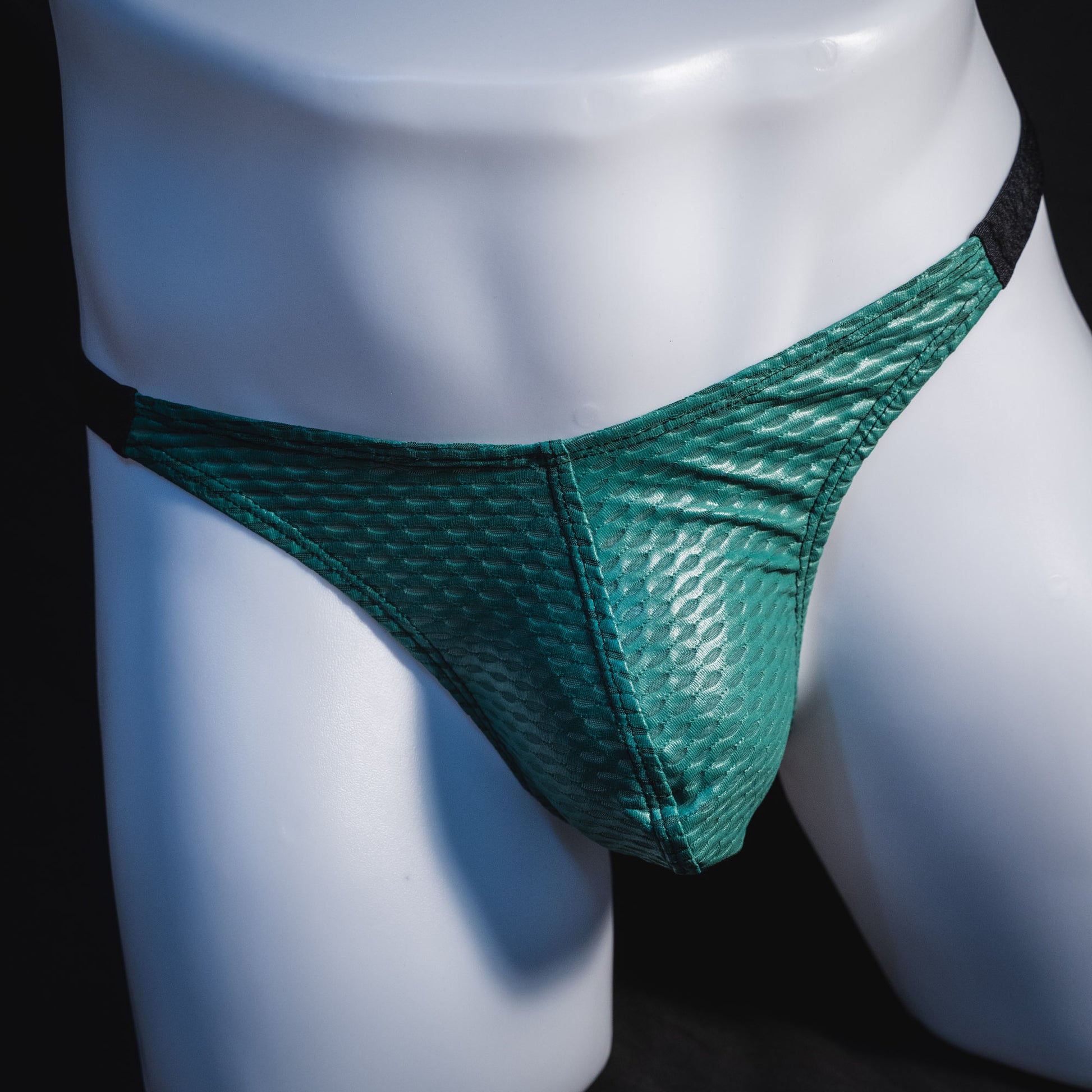 Men's green and black mesh thong underwear, classic cut, front view.