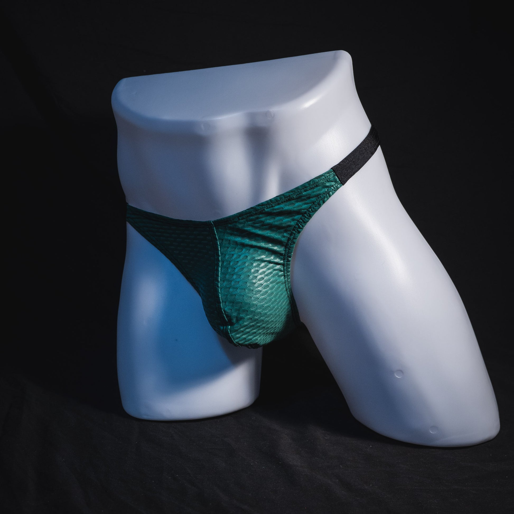 Men's green and black mesh thong underwear, classic cut, full angled front view.