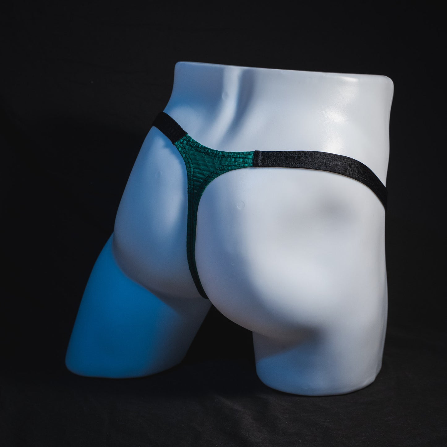 Men's green and black mesh thong underwear, classic cut, full angled rear view.