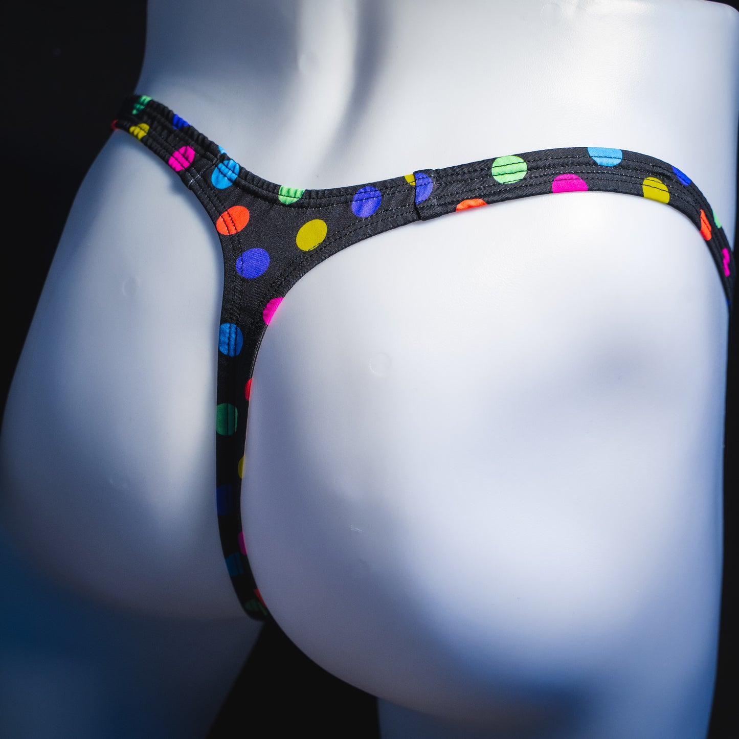 Men's multi colored polka dot thong underwear, classic cut, angled rear view.