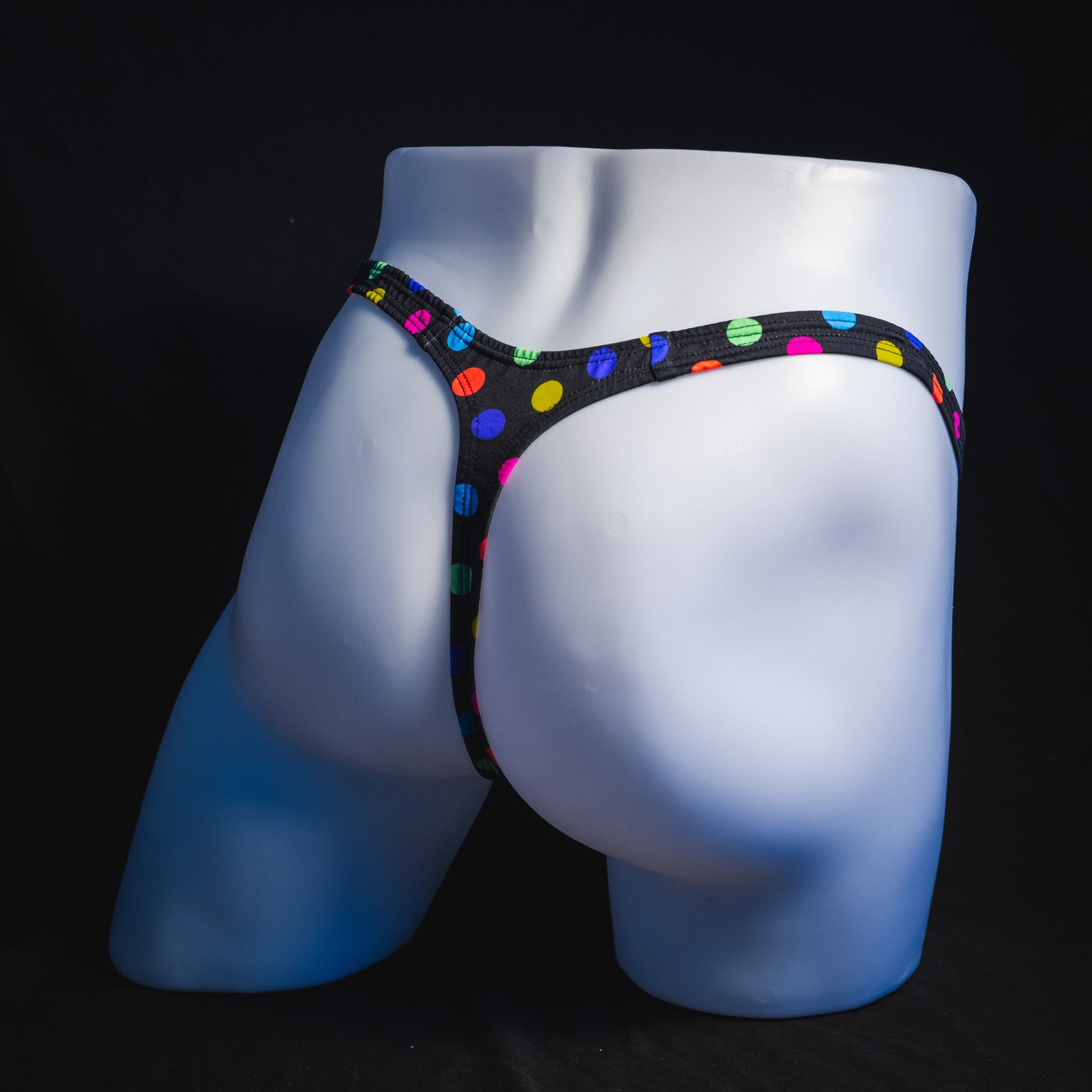 Men's multi colored polka dot thong underwear, classic cut, full angled rear view.