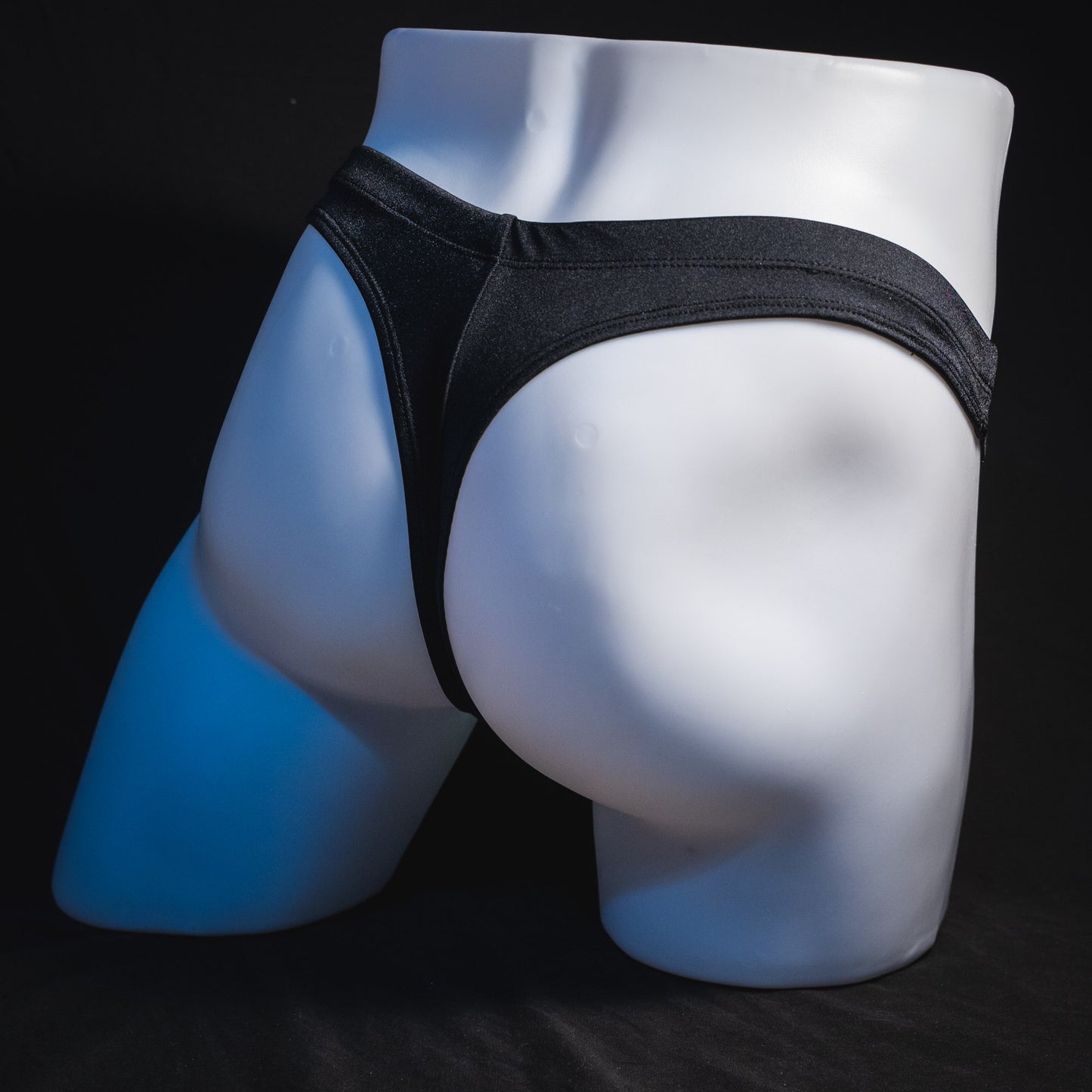 Men's black thong underwear, full angled rear view.