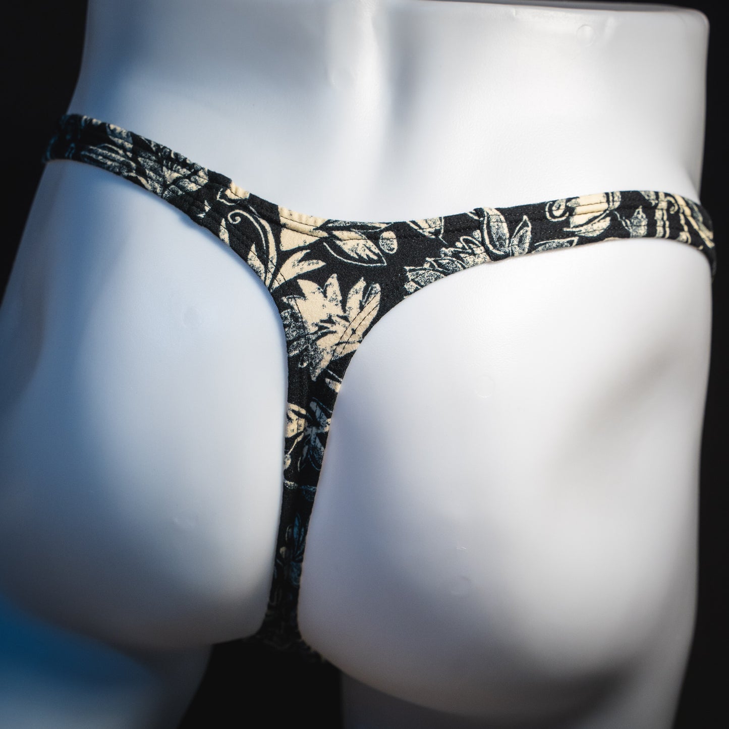 Men's black and white paisley thong underwear, classic cut, rear view.