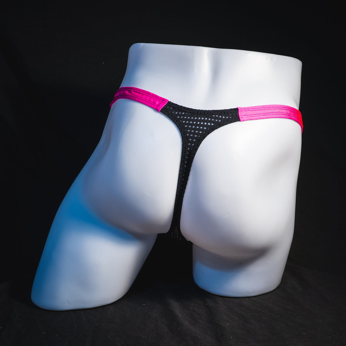 Men's bright pink and black mesh thong underwear, classic cut, full rear view.