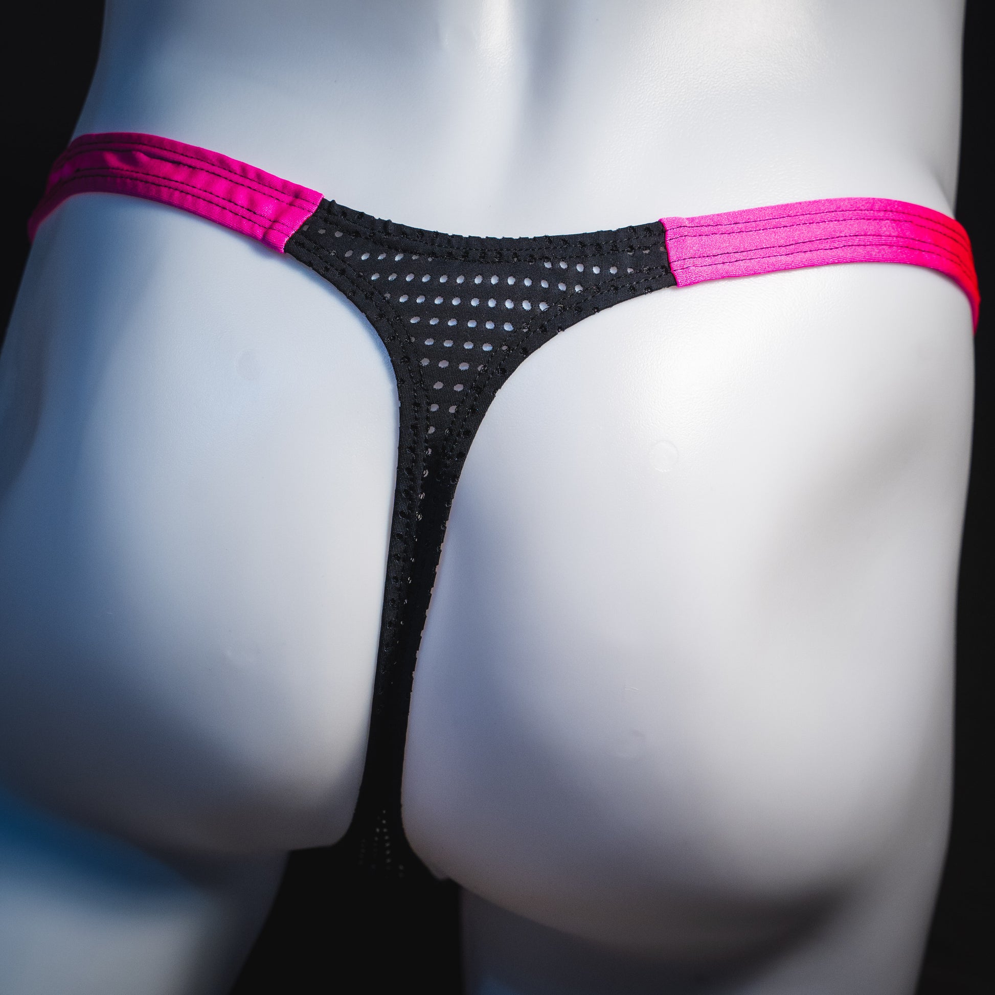 Men's bright pink and black mesh thong underwear, classic cut, rear view.