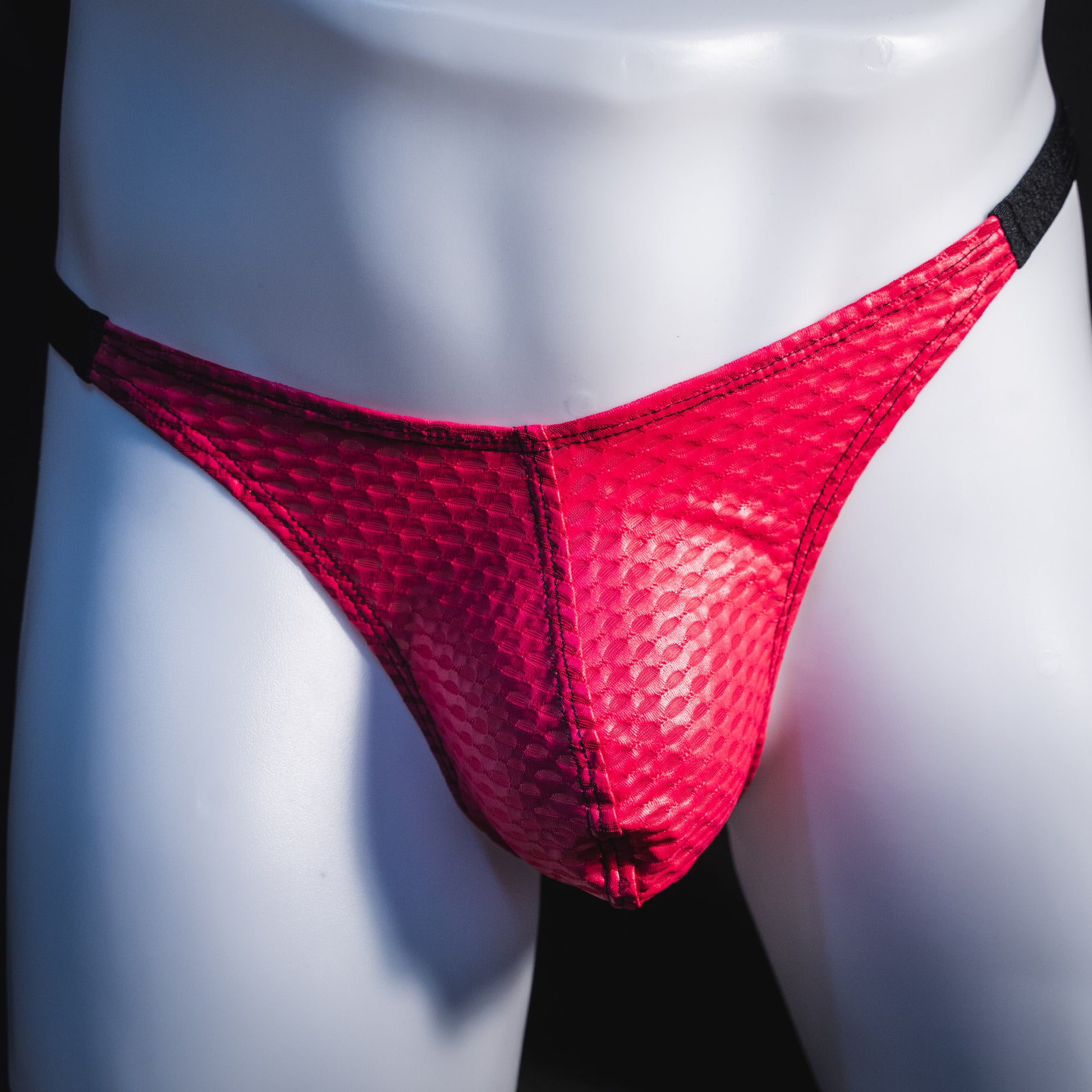 Men's pink athletic mesh thong underwear, classic cut, front view.