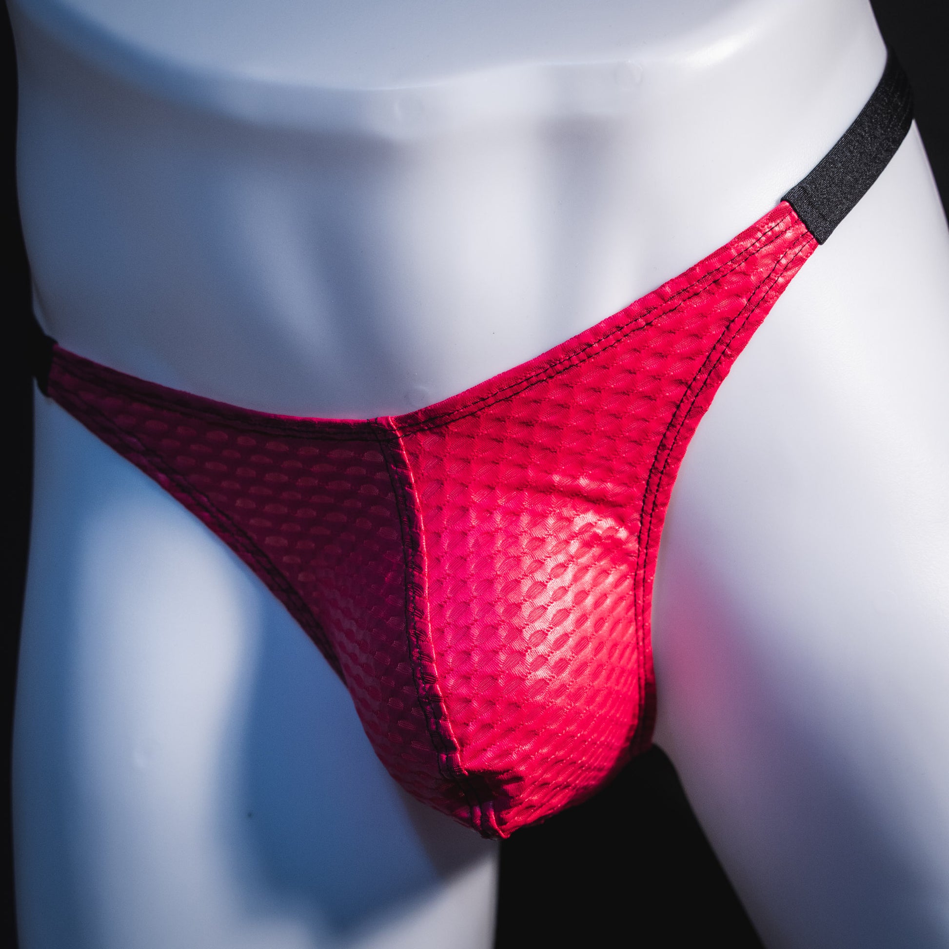 Men's pink athletic mesh thong underwear, classic cut, angled front view.