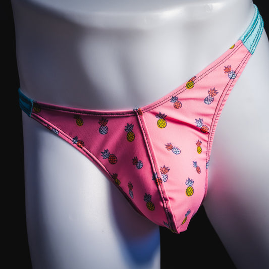 Men's bright pink and blue tropical thong underwear with pineapples, classic cut, front view.