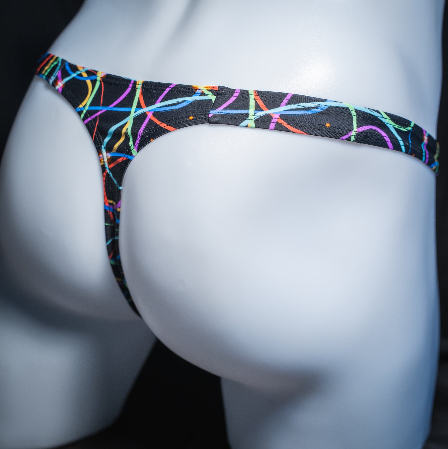 Men's colorful lines thong, classic cut, angled rear view.