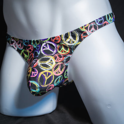 Men's colorful peace sign thong, classic cut, angled front view.
