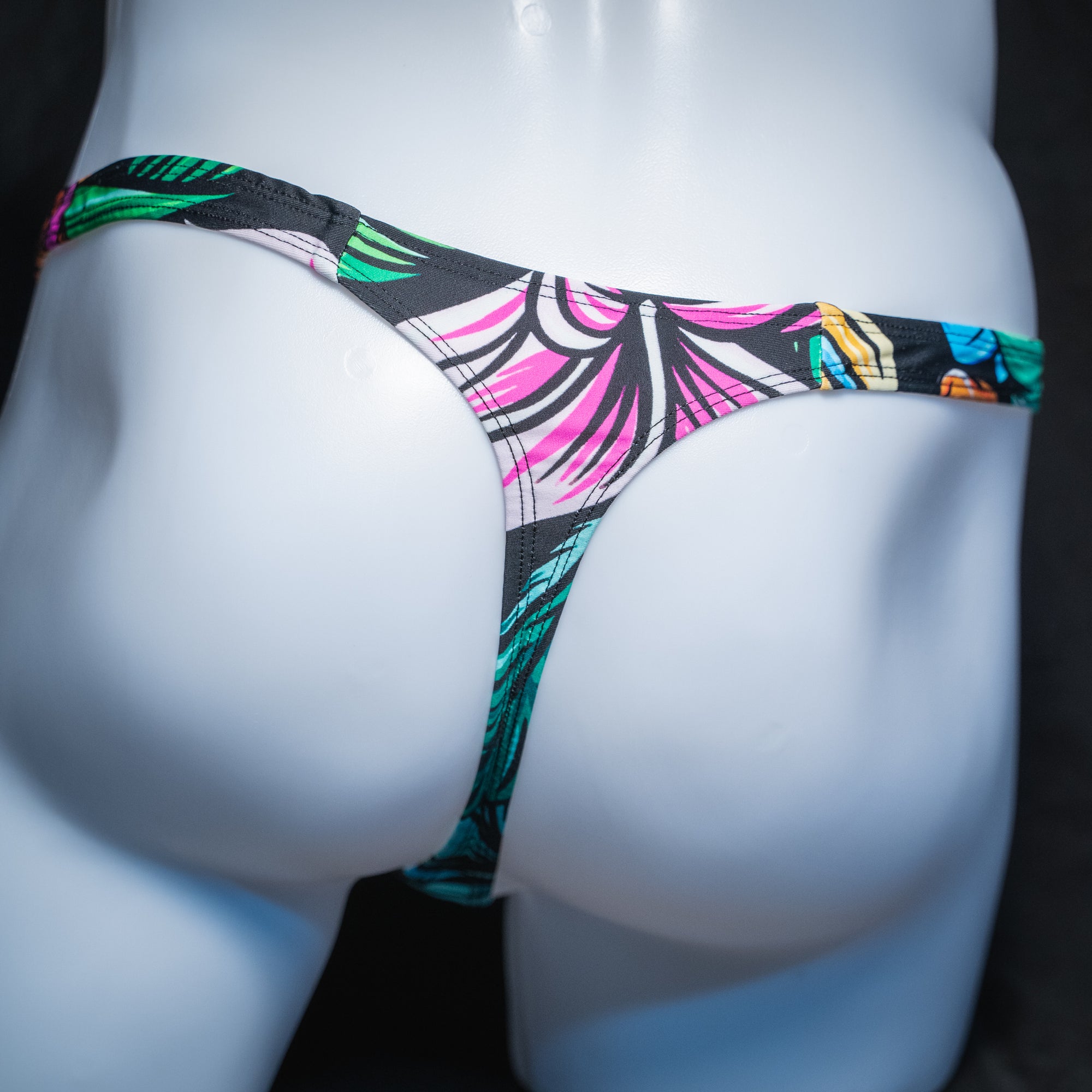 Men's colorful hip floral thong, slim cut, rear view.