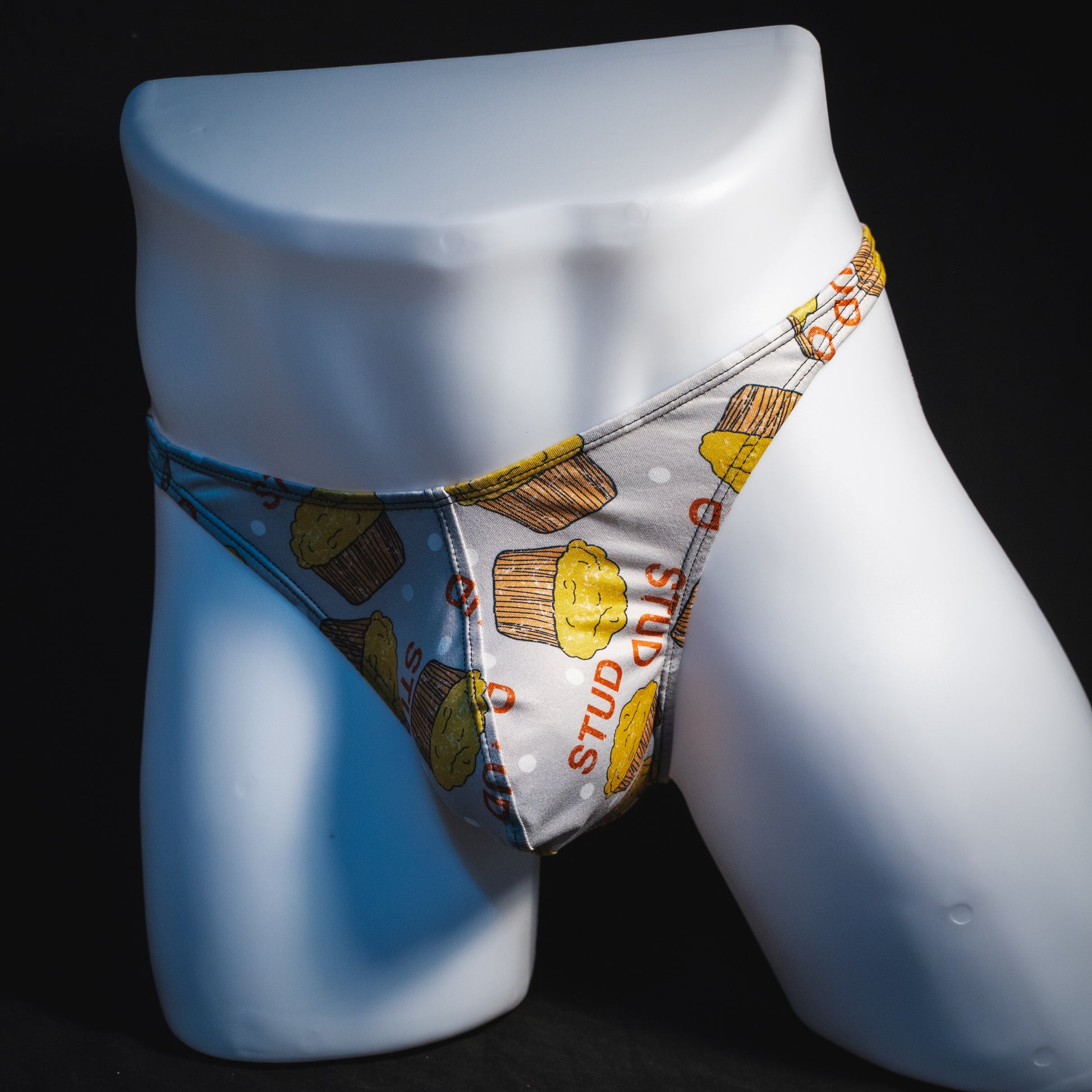 Men's stud muffin thong underwear, classic cut, full front angled view.