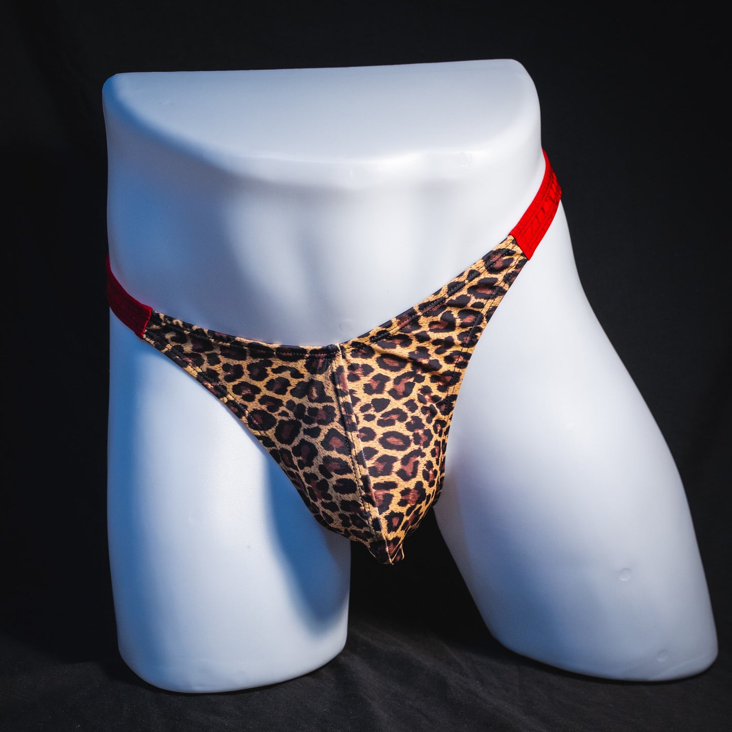 Men's cheetah print thong with red waistband, classic cut, full front view.