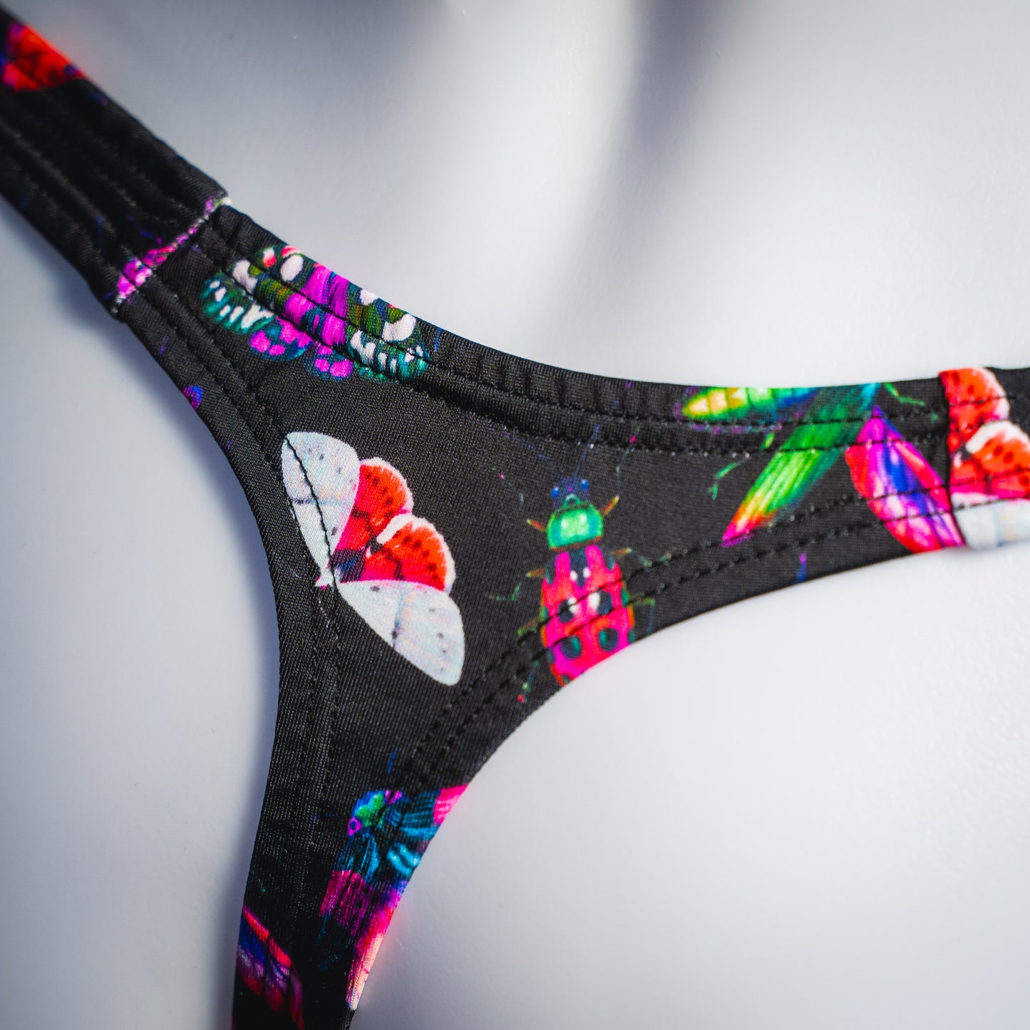 Men's black with pink insects thong underwear, Classic cut, rear detail view.