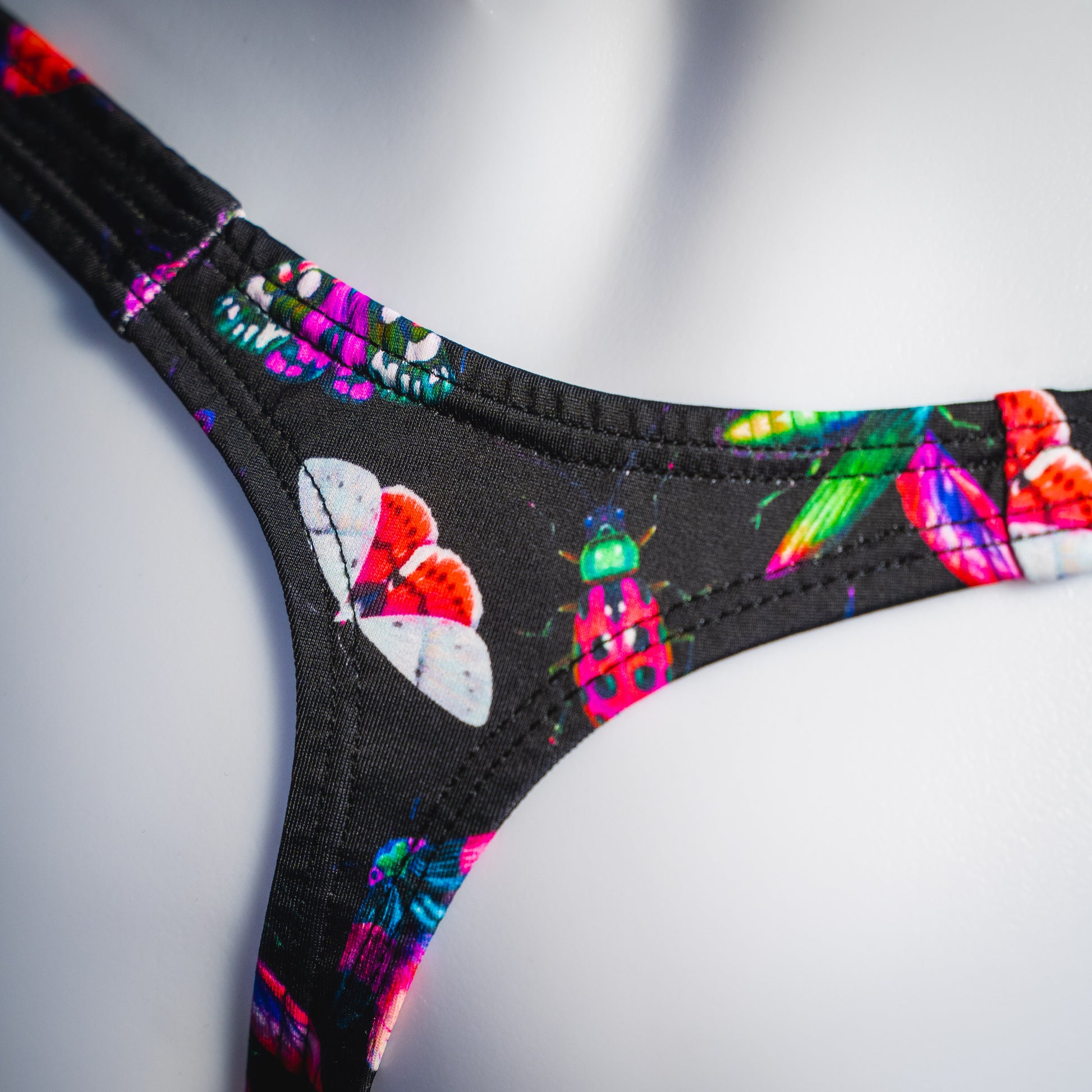 Men's black with pink insects thong underwear, Classic cut, rear detail view.