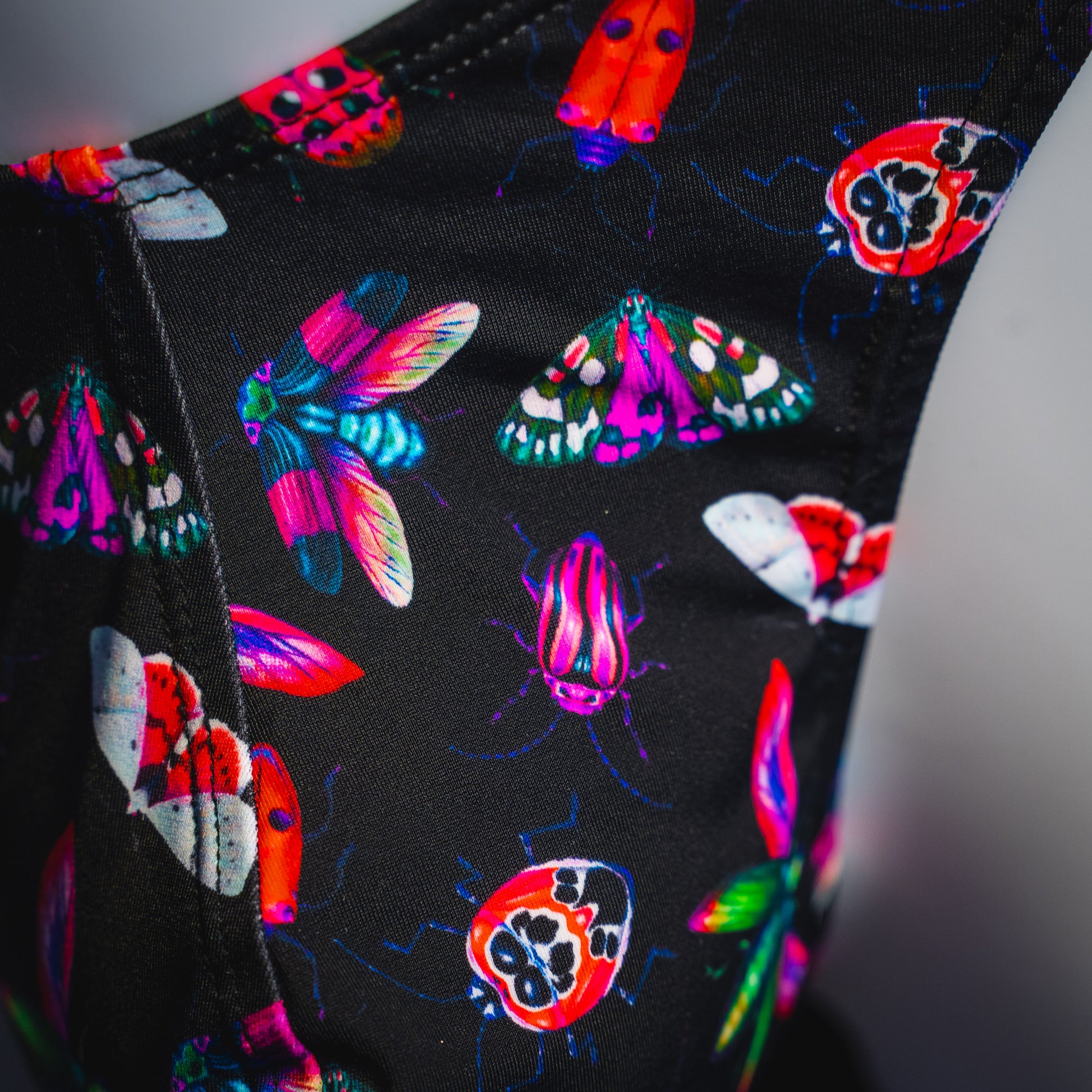 Men's black with pink insects thong underwear, Classic cut, detailed view.