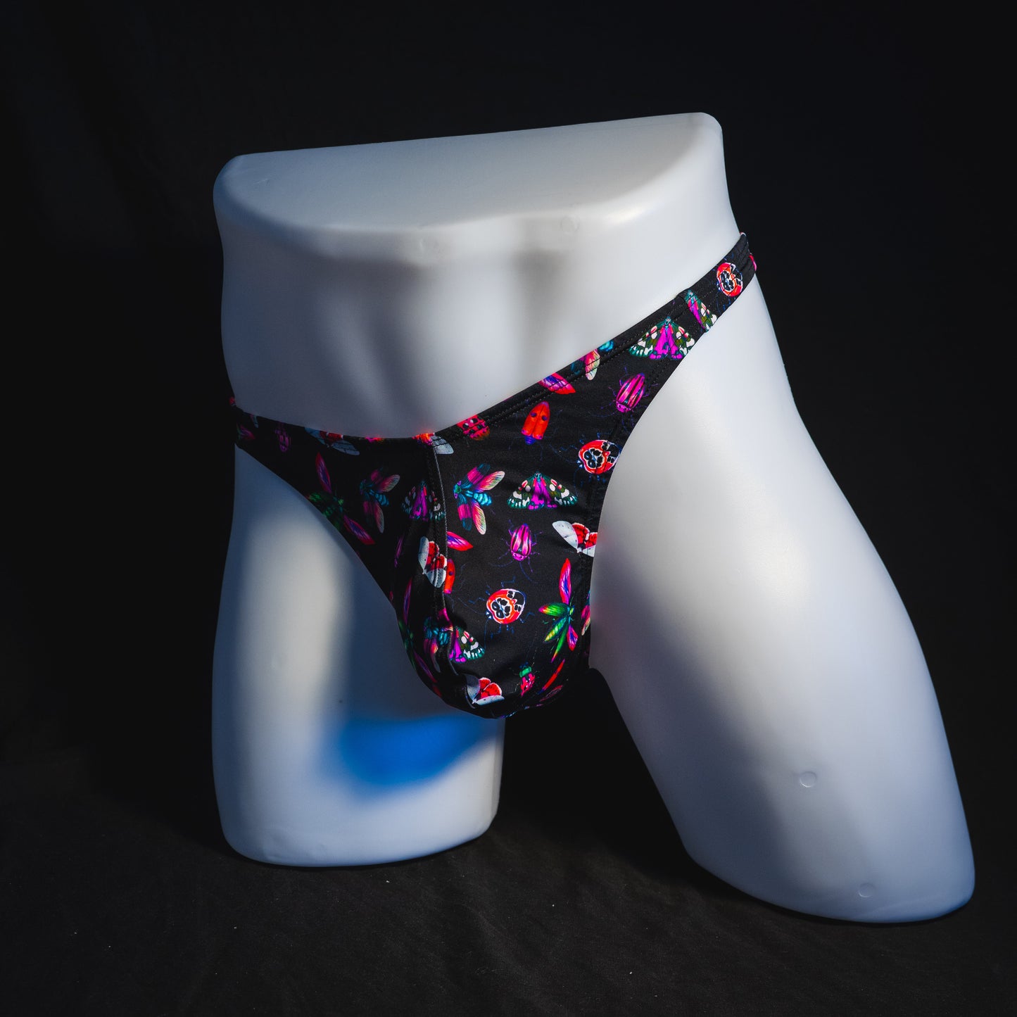 Men's black with pink insects thong underwear, Classic cut, full angled front view.