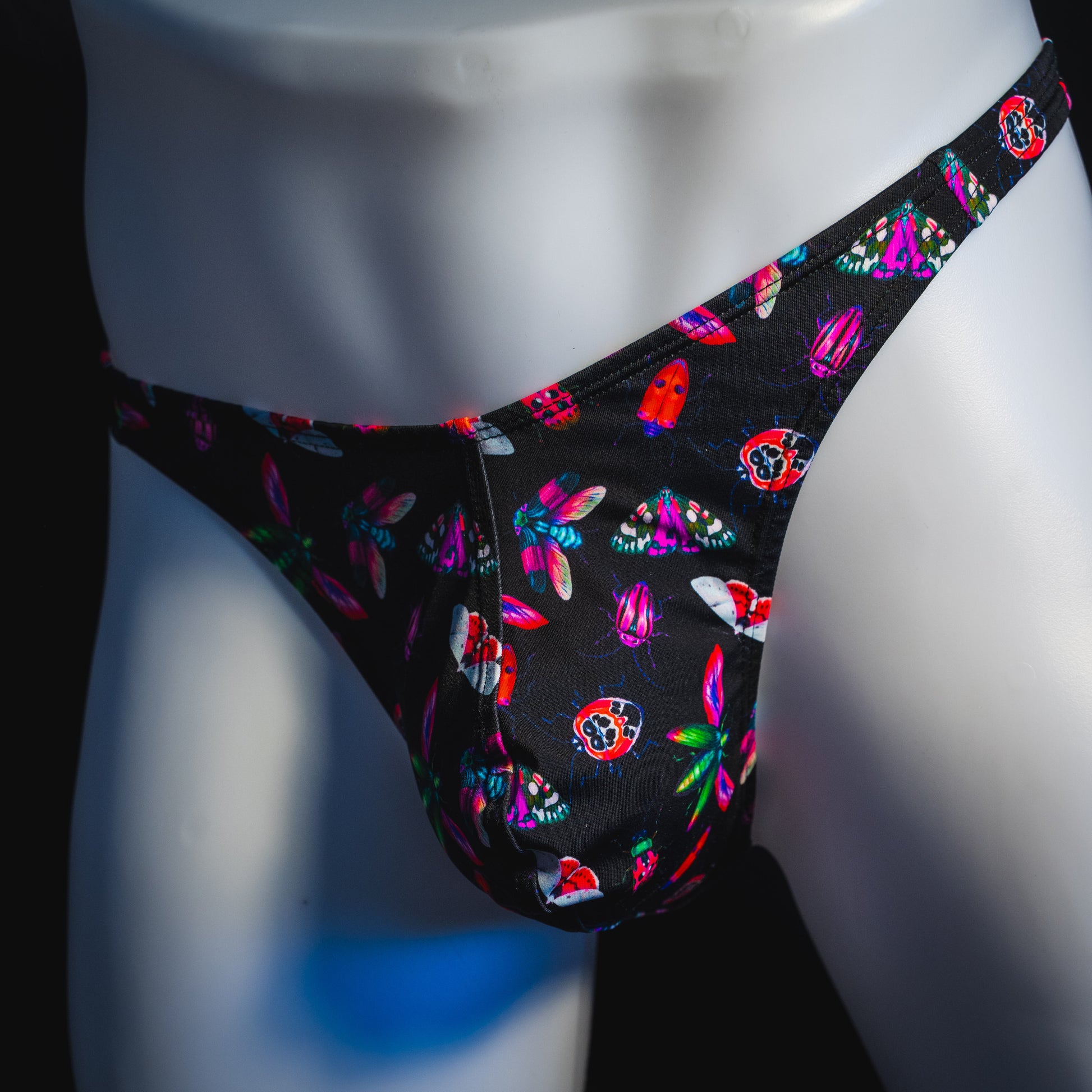 Men's black with pink insects thong underwear, Classic cut, front angled view.