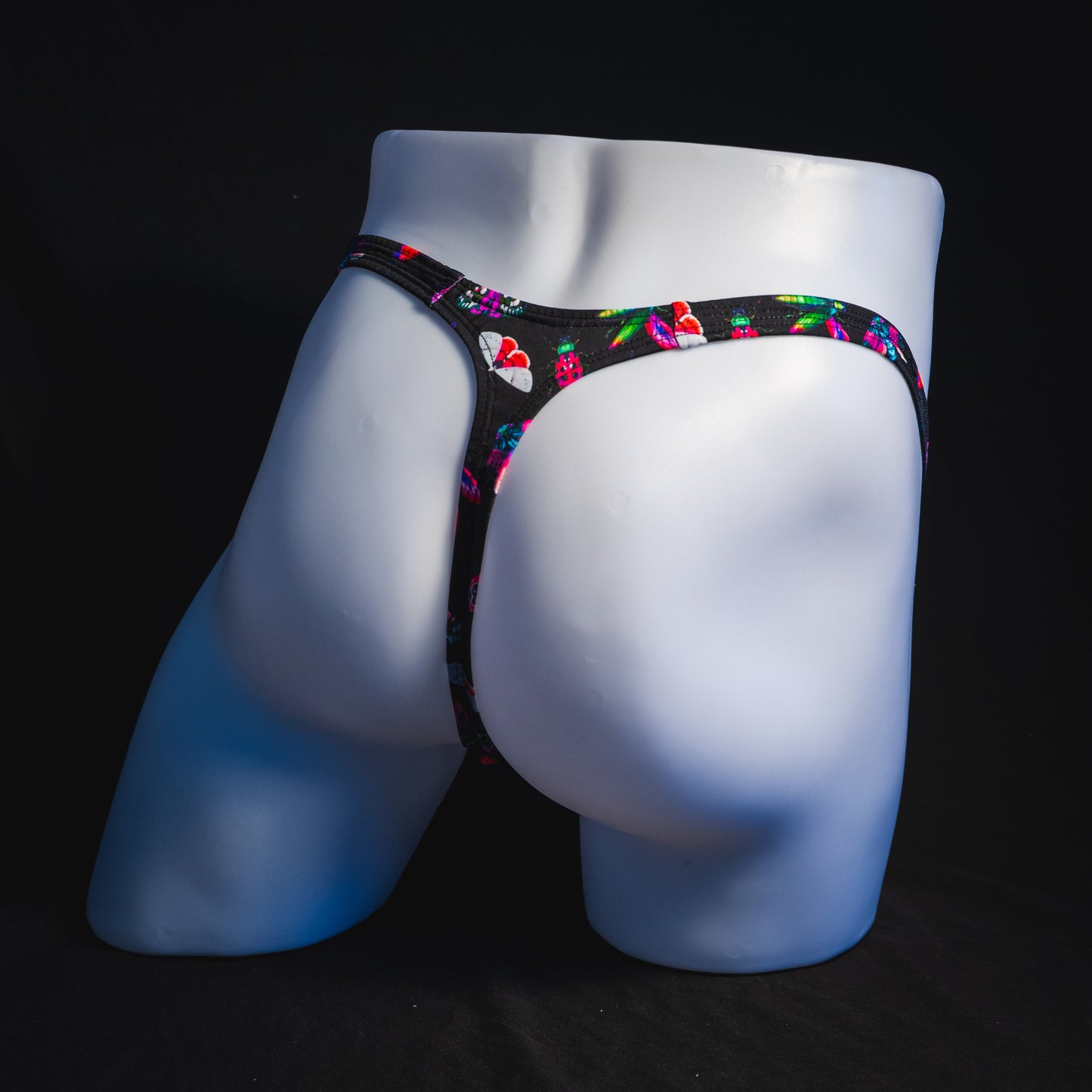 Men's black with pink insects thong underwear, Classic cut, full angled rear view.