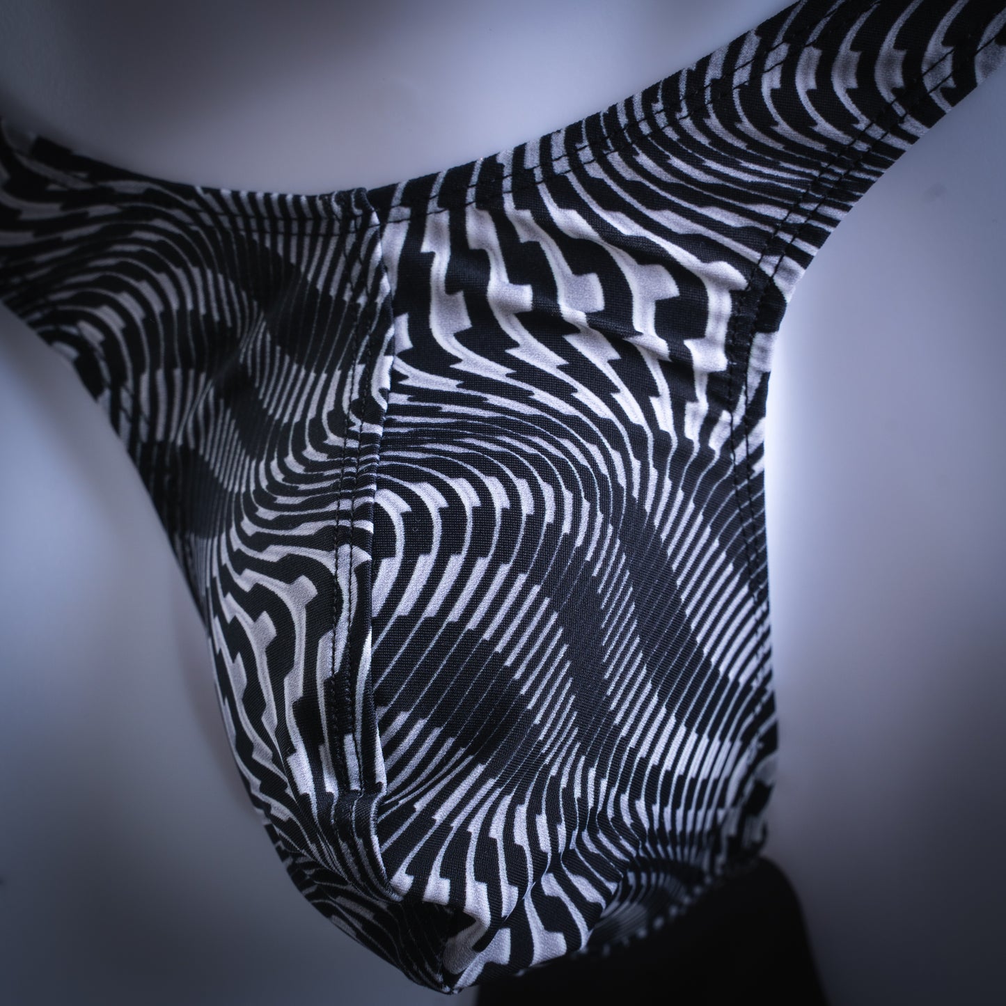 Men's abstract black and white thong, slim cut, closeup front view.