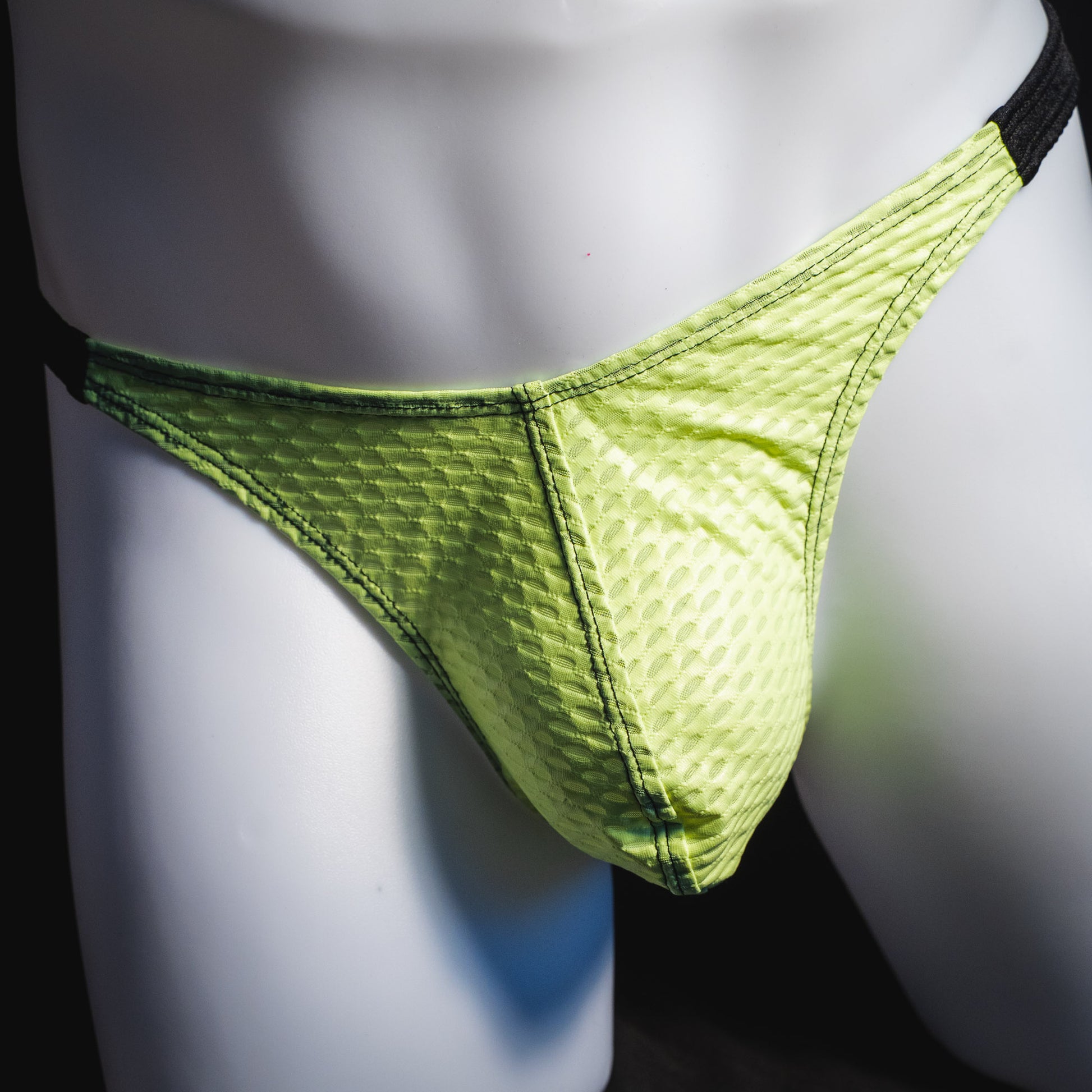 Men's lime green and black athletic mesh thong underwear, classic cut, front view.