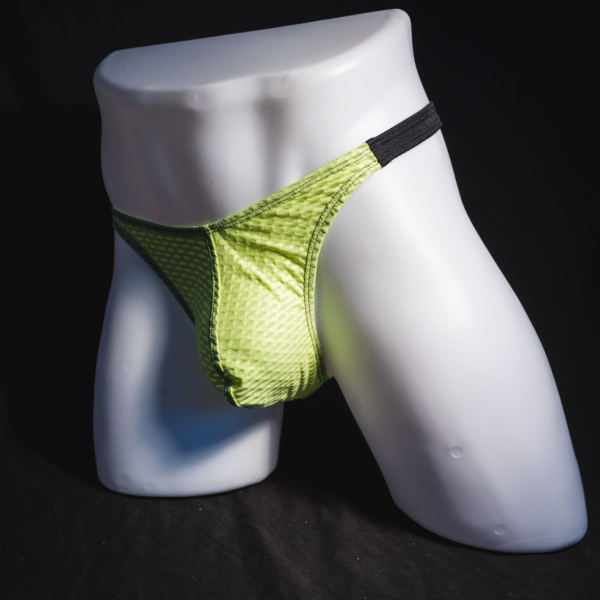 Men's lime green and black athletic mesh thong underwear, classic cut, full angled front view.