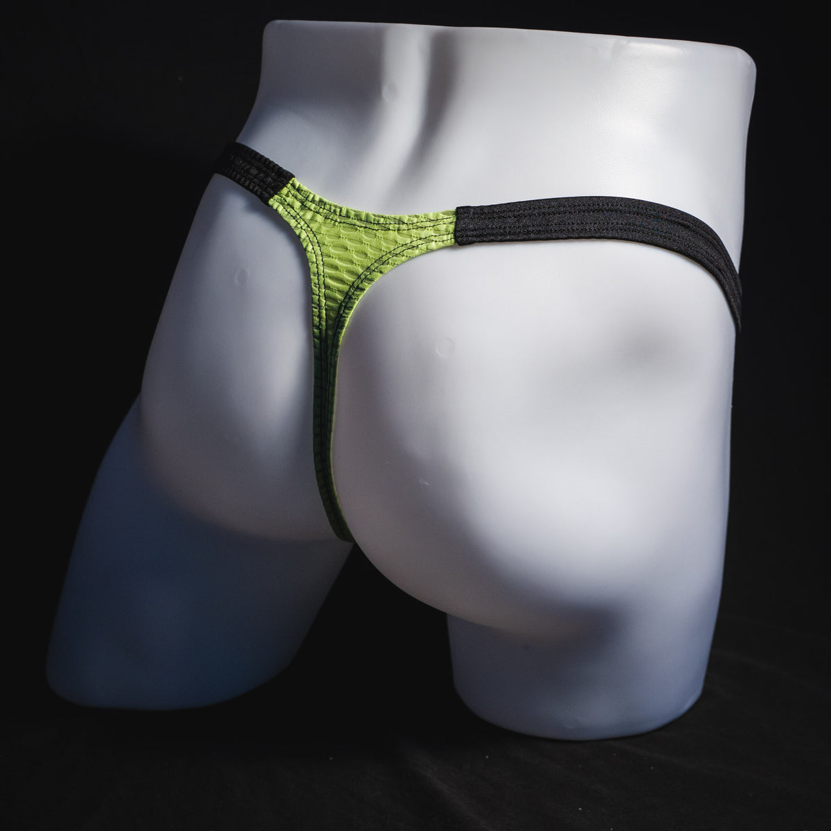 Men's lime green and black athletic mesh thong underwear, classic cut, full angled rear view.