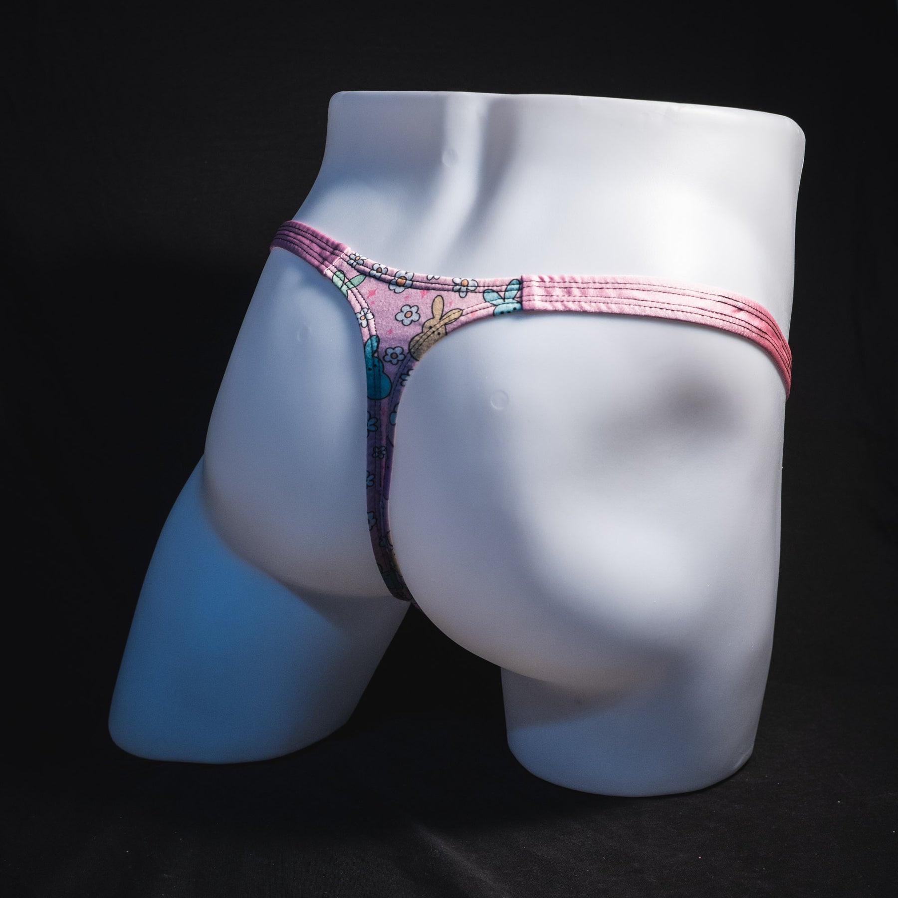 Men's pink easter bunnies thong underwear, classic cut, full angled rear view.