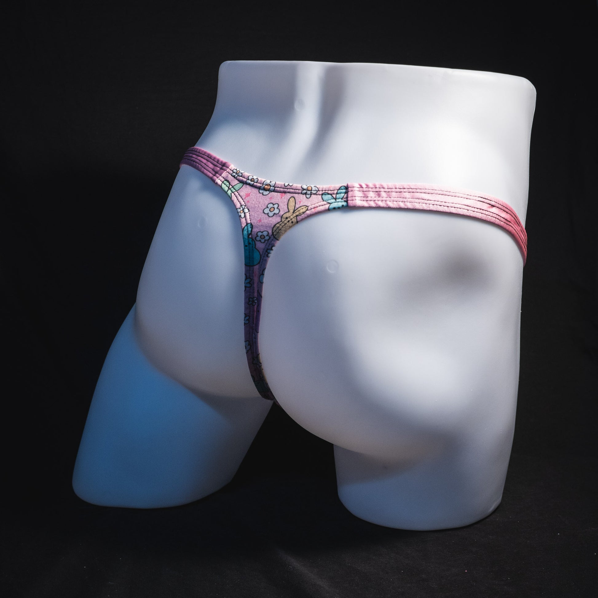 Men's pink easter bunnies thong underwear, classic cut, full angled rear view.