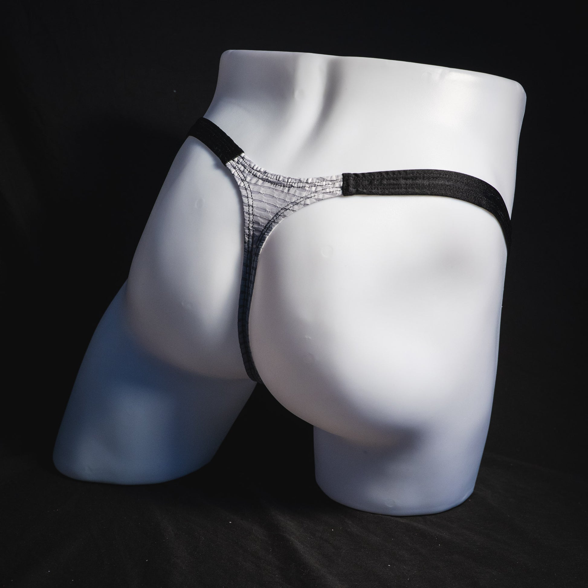 Men's ash white and black athletic mesh thong underwear, classic cut, full angled rear view.