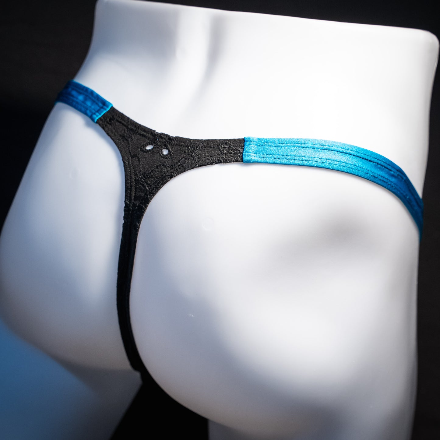Men's black and blue eyelet thong underwear, classic cut, rear view.