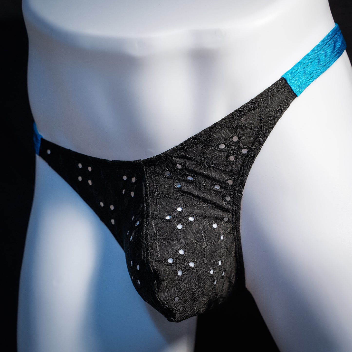 Men's black and blue eyelet thong underwear, classic cut, front view.