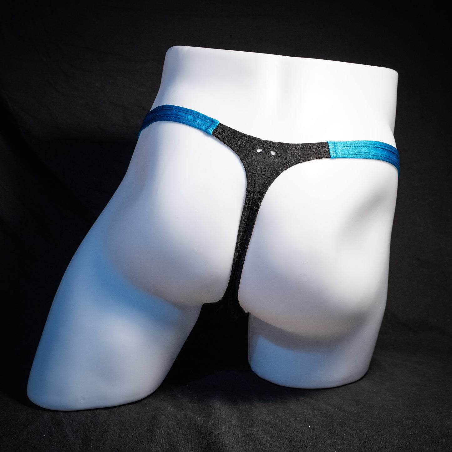 Men's black and blue eyelet thong underwear, classic cut, rear view.