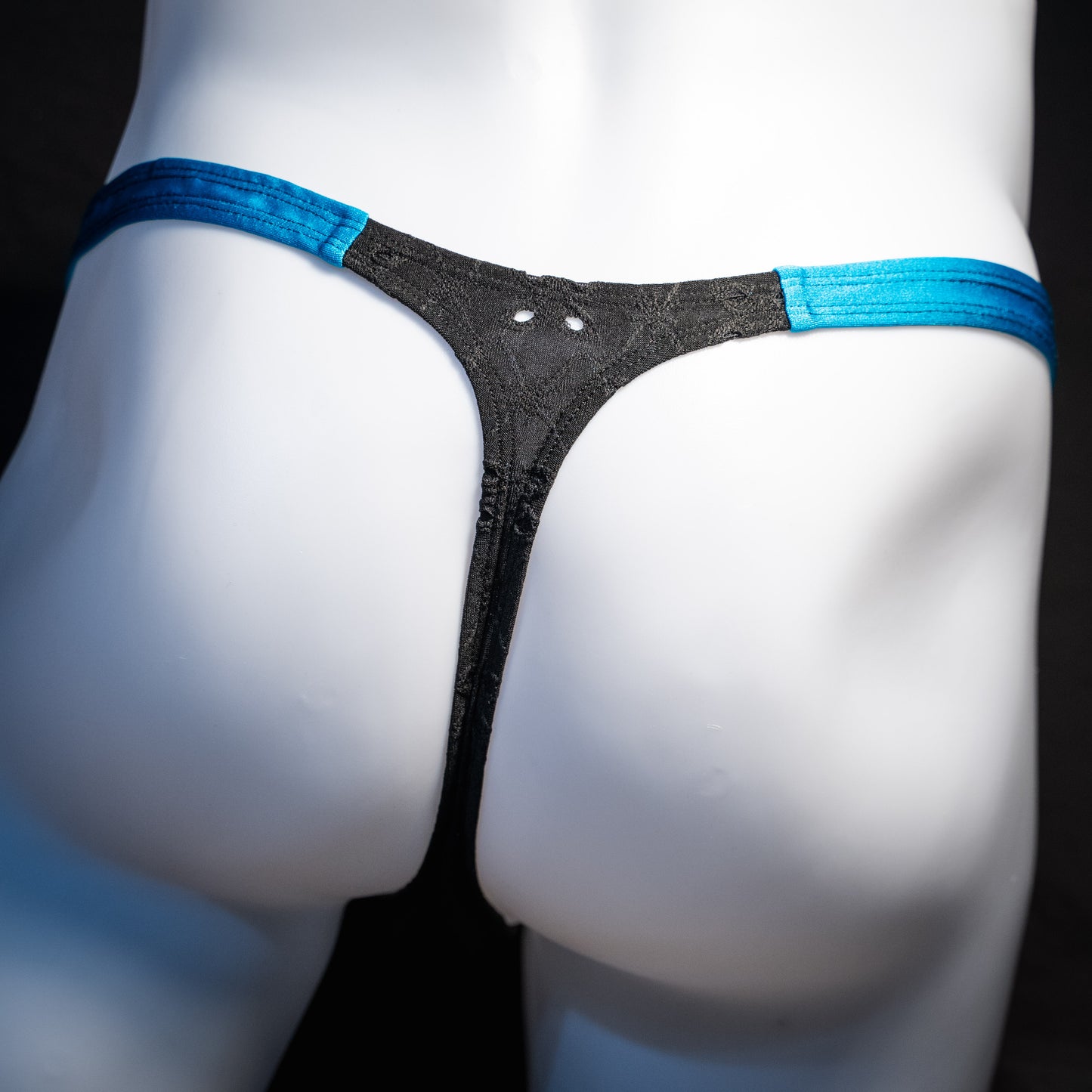 Men's black and blue eyelet thong underwear, classic cut, rear view.