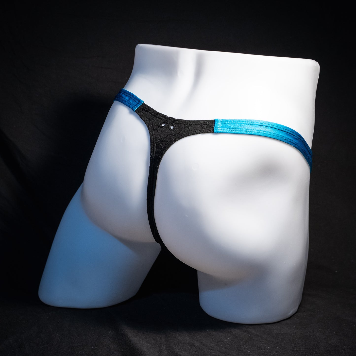 Men's black and blue eyelet thong underwear, classic cut, rear view.