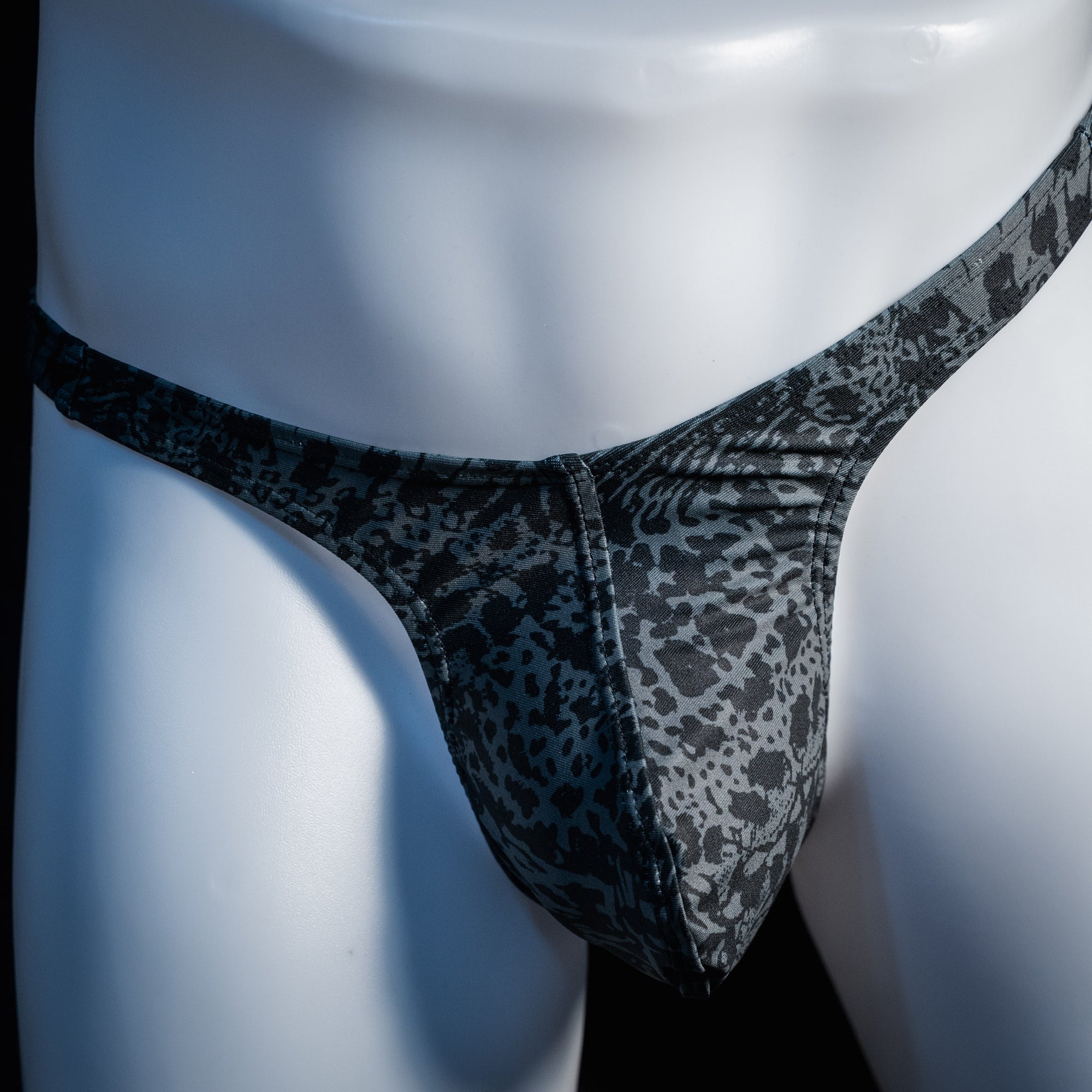 Men's black and grey abstract print thong underwear, slim cut, front view.