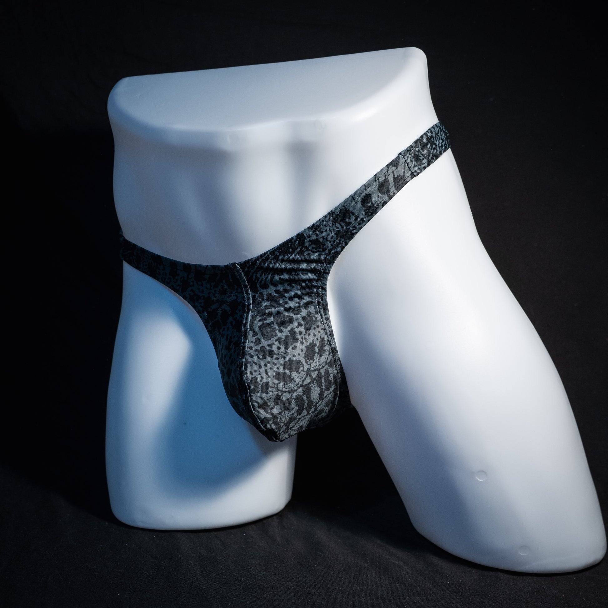 Men's black and grey abstract print thong underwear, slim cut, front view.