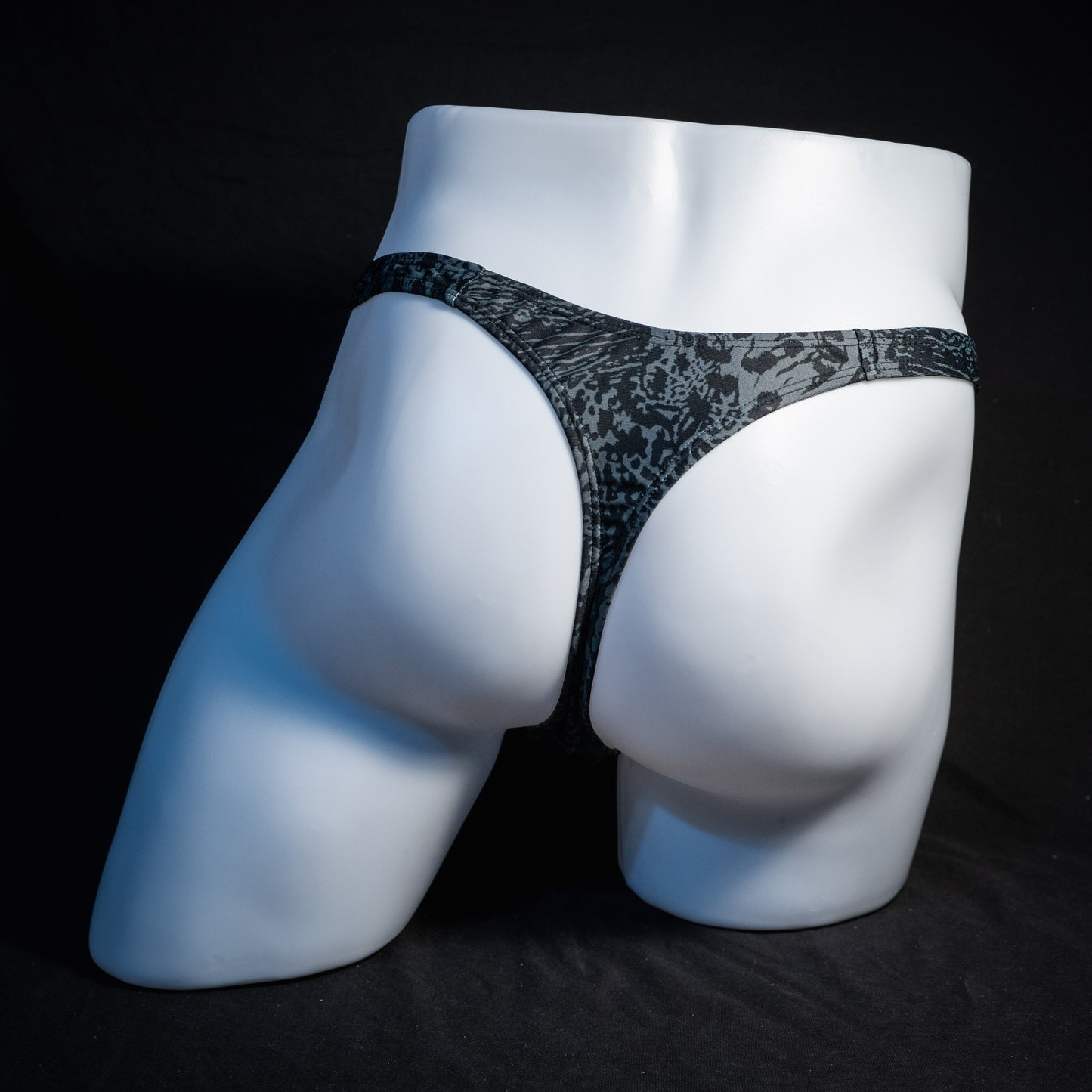 Men's black and grey abstract print thong underwear, slim cut, rear view.