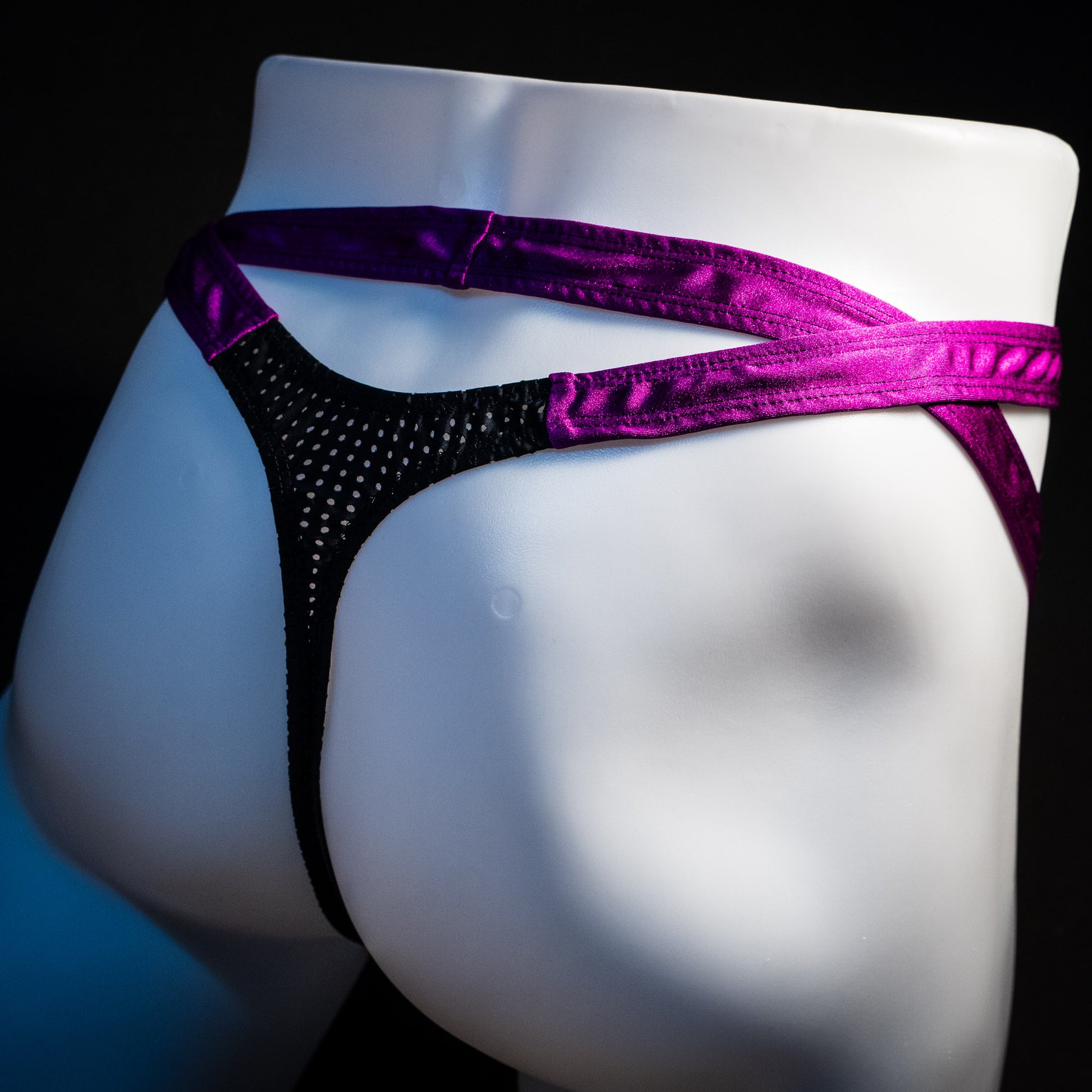 Men's double strap black mesh with purple straps, thong underwear, tower cut, rear angled view.