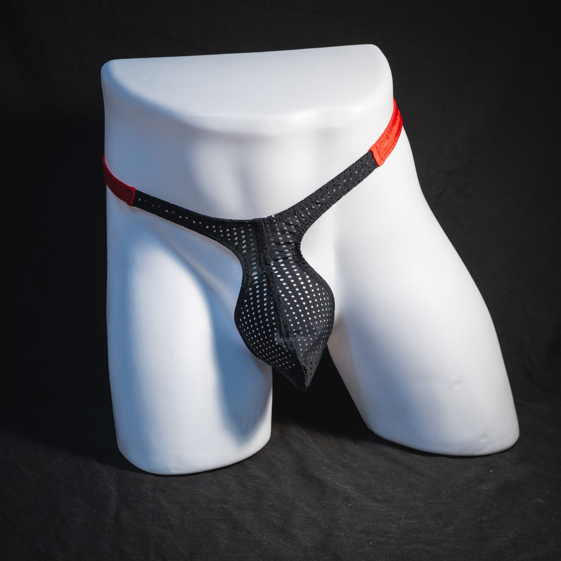 Men's black and red mesh thong underwear, classic cut, full front view.