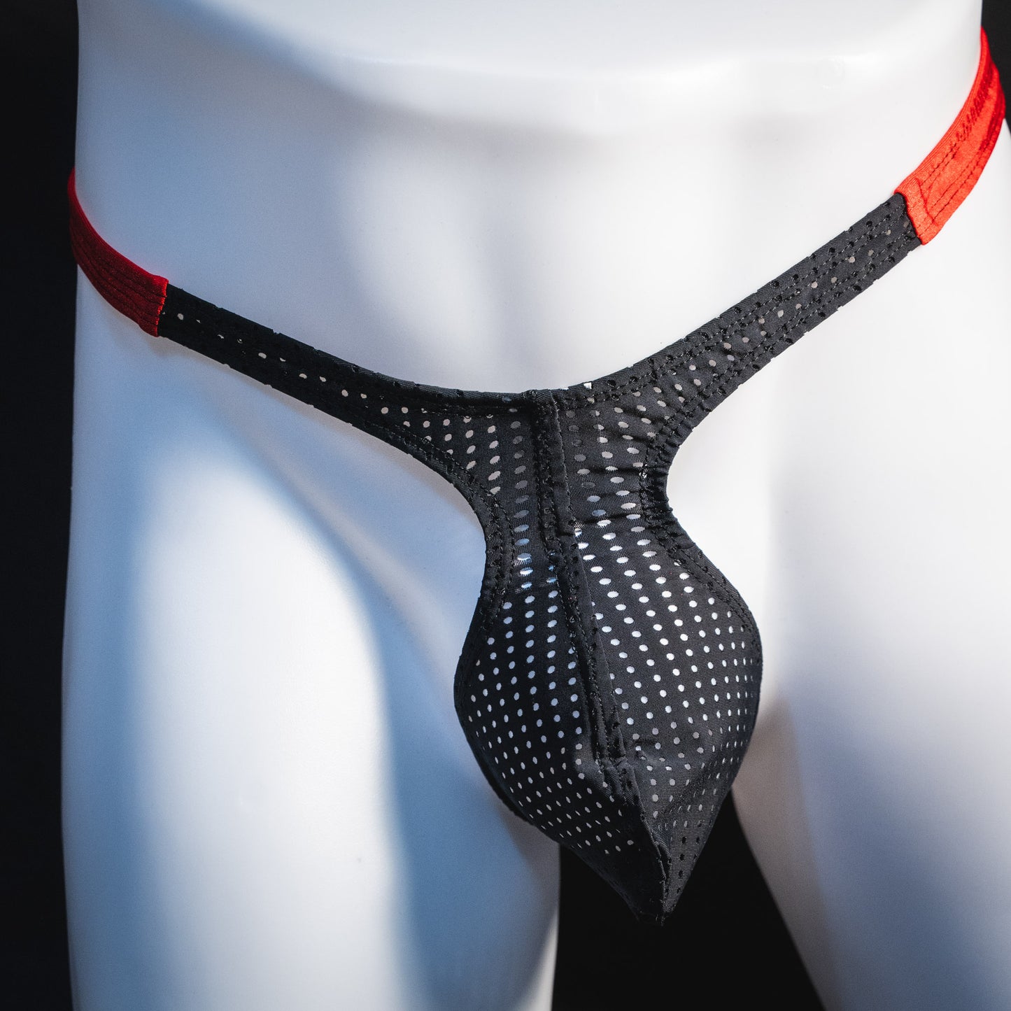 Men's black and red mesh thong underwear, classic cut, front view.