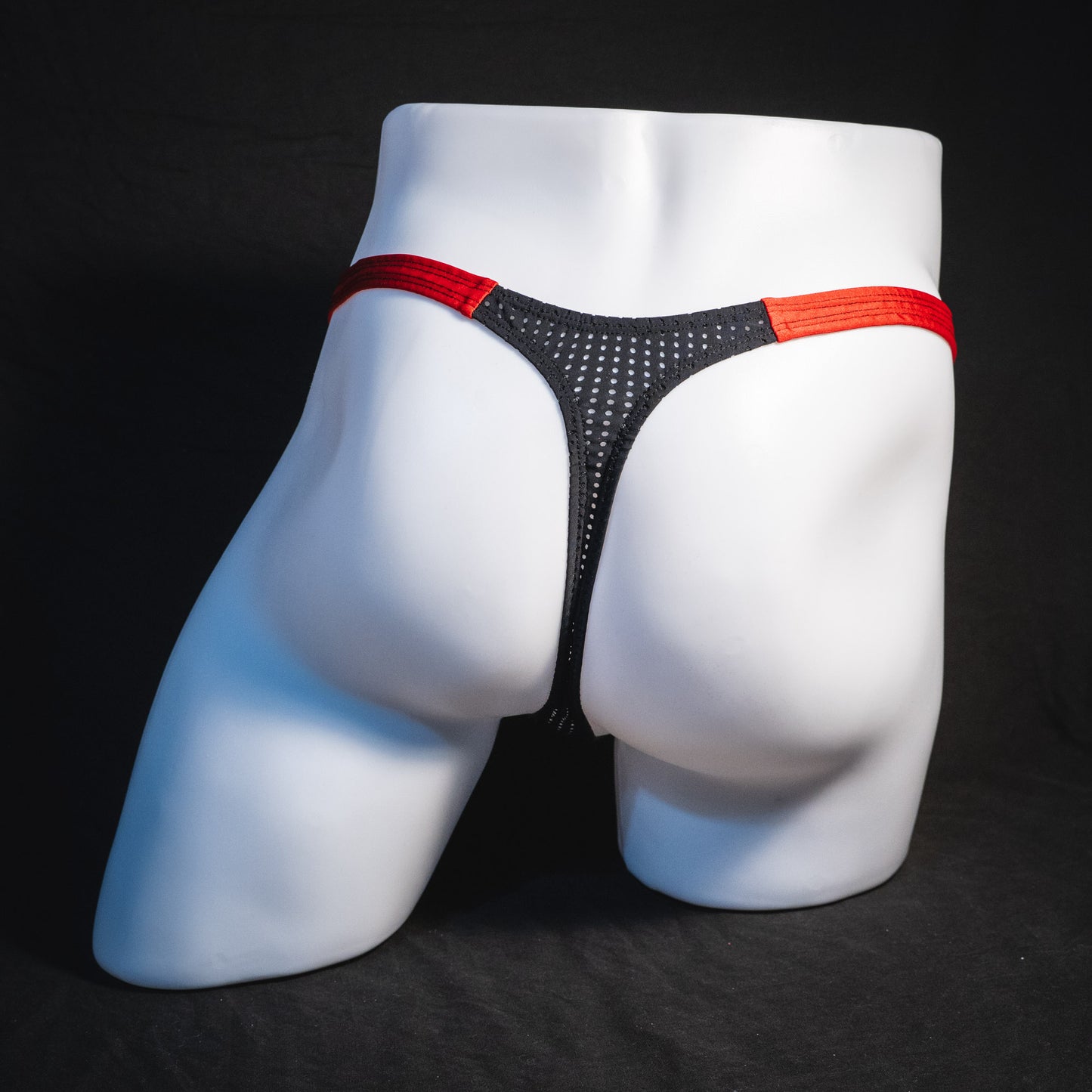 Men's black and red mesh thong underwear, classic cut, full rear view.