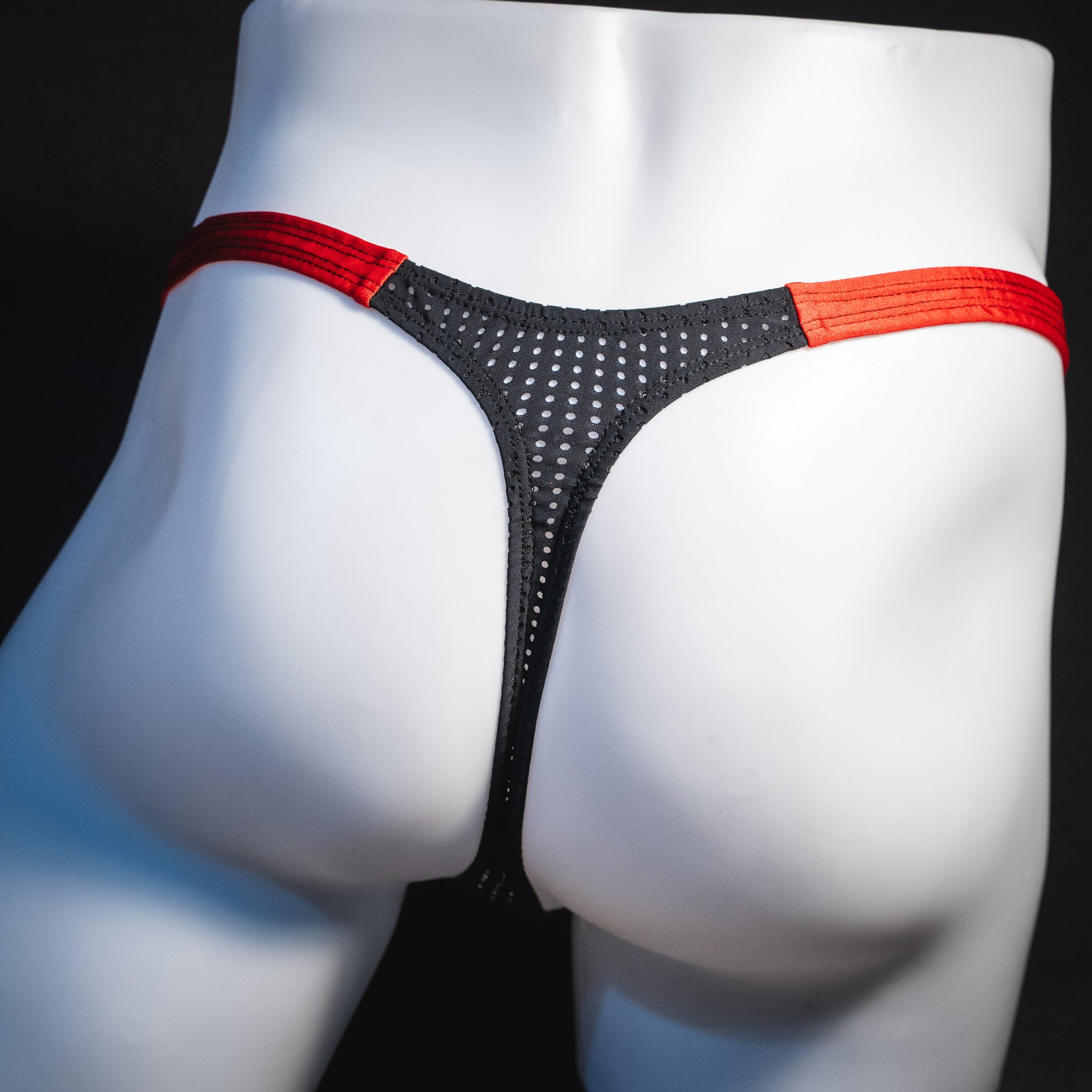 Men's black and red mesh thong underwear, classic cut, rear view.