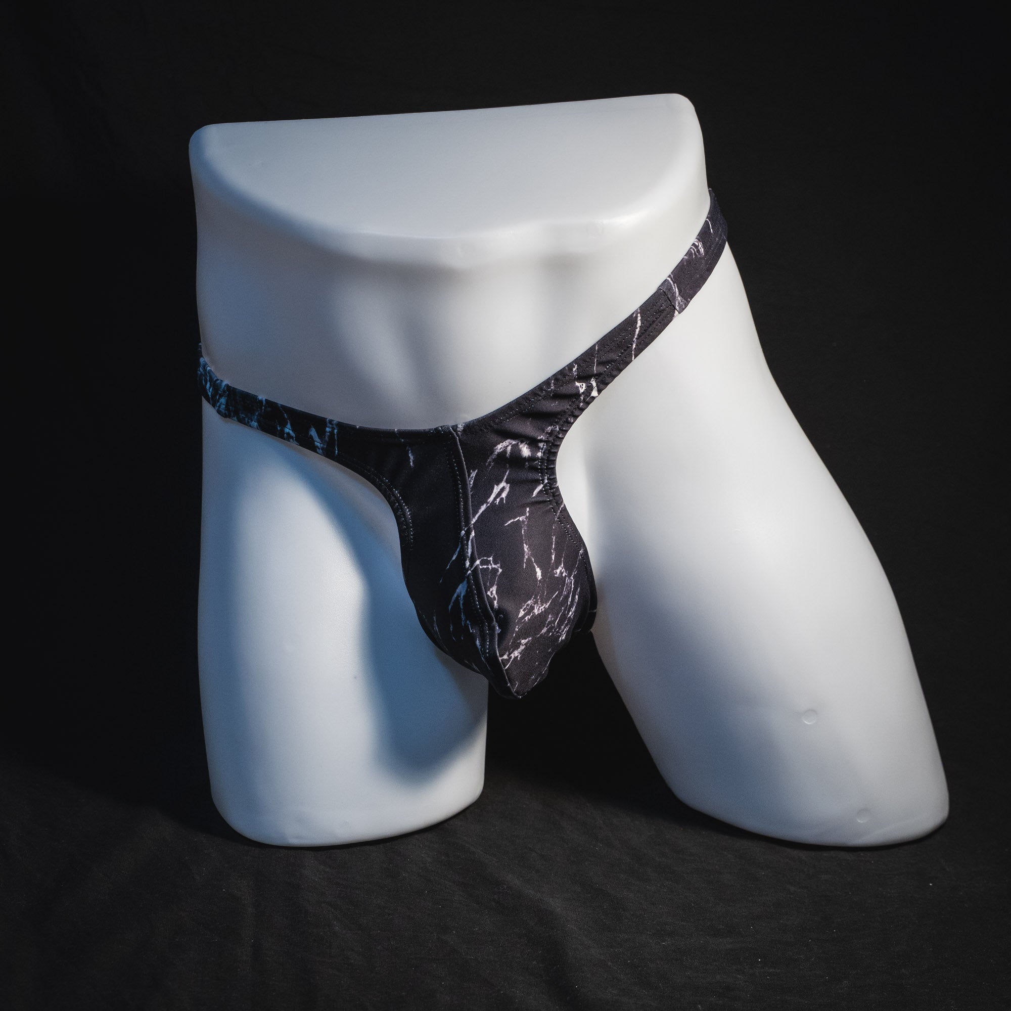 Men's black and white marble thong underwear, tower cut, full front view.