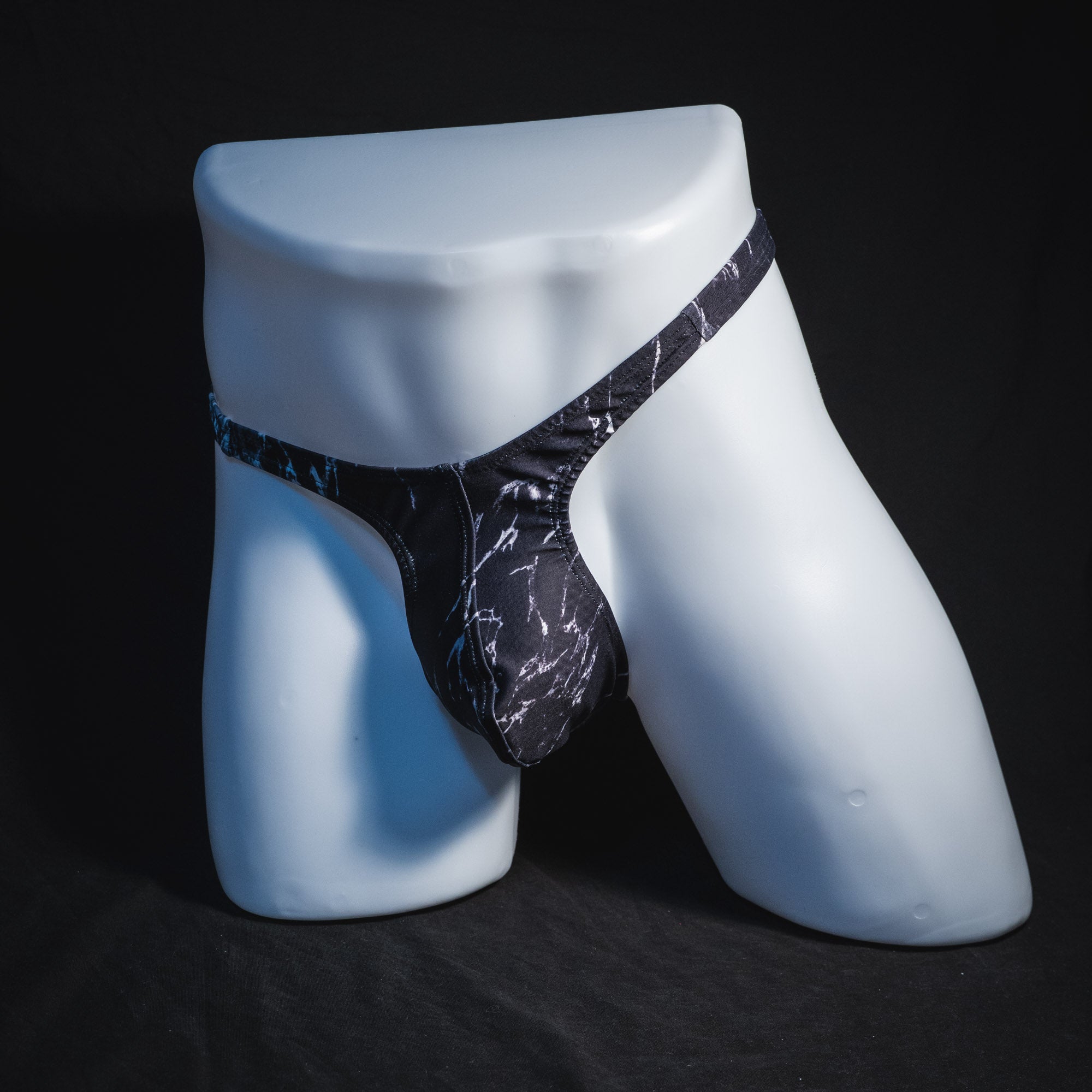 Men's black and white marble thong underwear, tower cut, full angled front view.