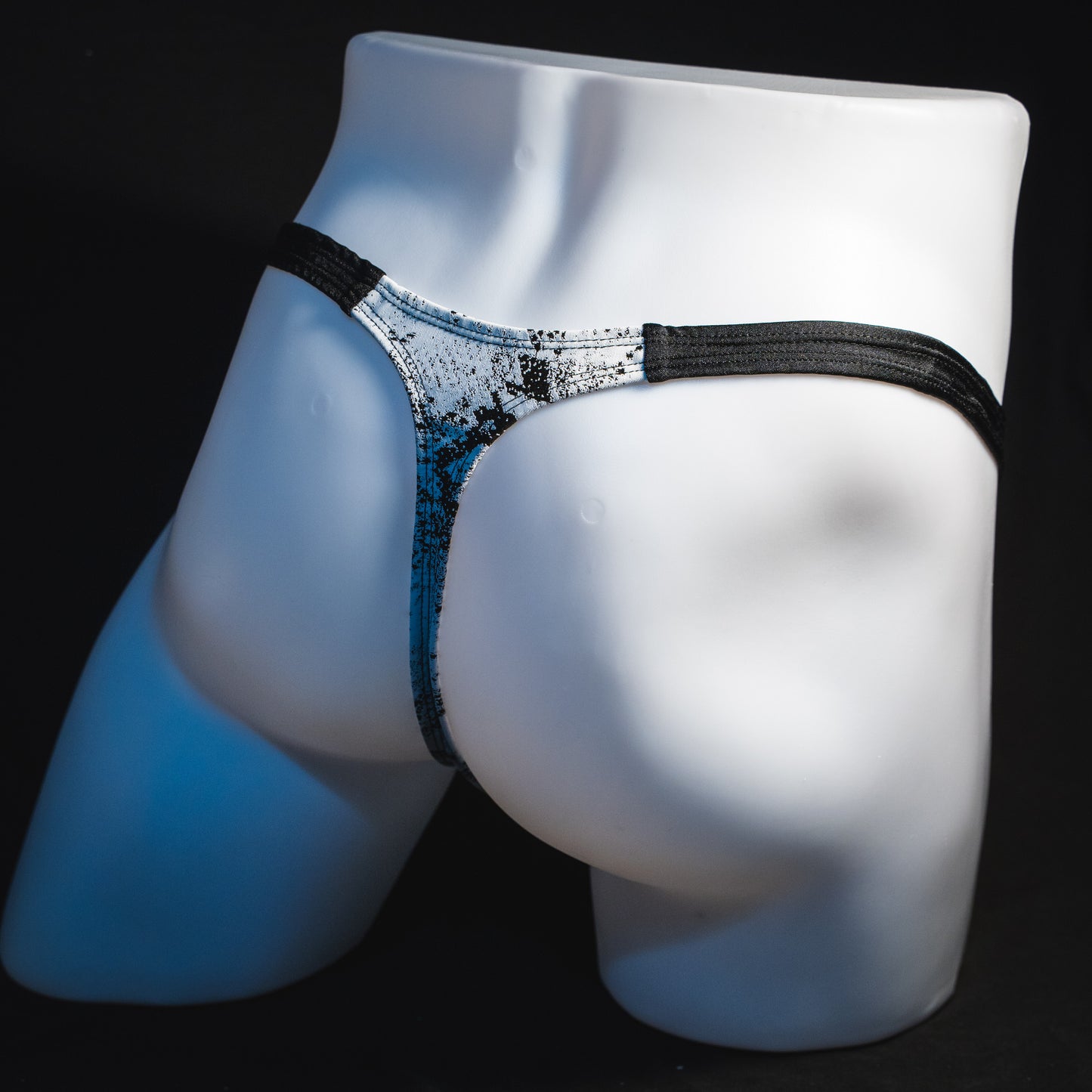 Men's black and white snakeskin thong underwear, classic cut, angled full rear view.